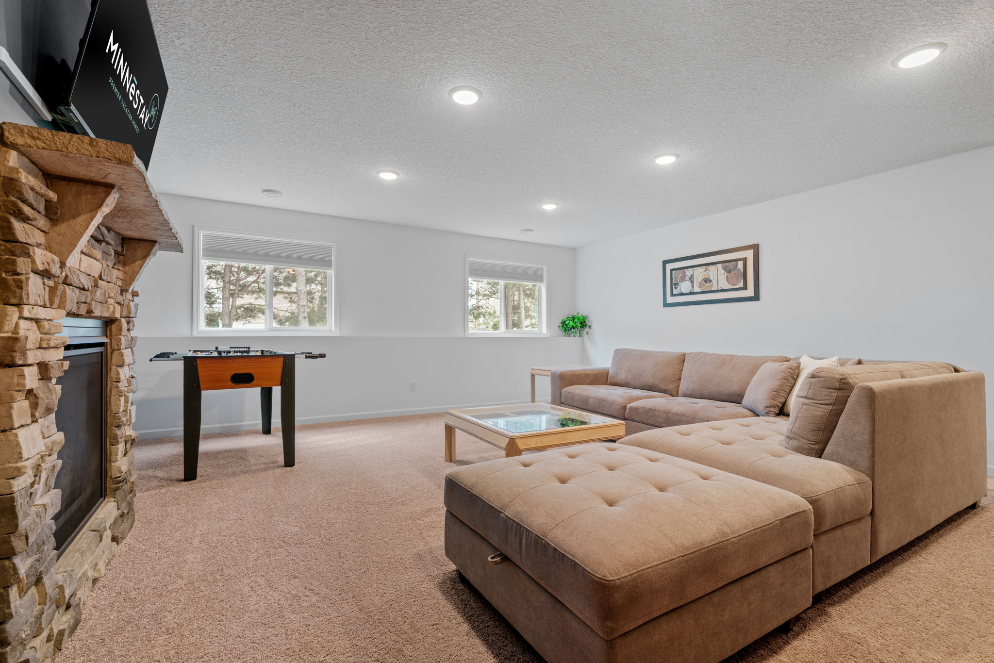A cozy living room featuring a plush sectional sofa and foosball table.