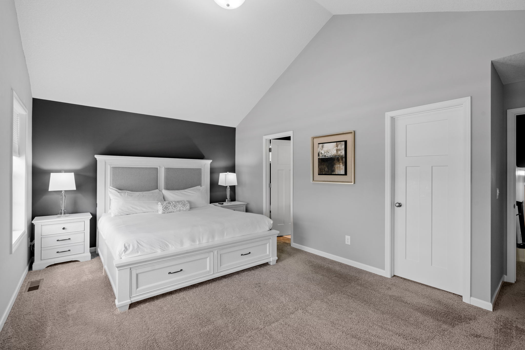 A modern and cozy bedroom with a high ceiling and elegant furnishings.