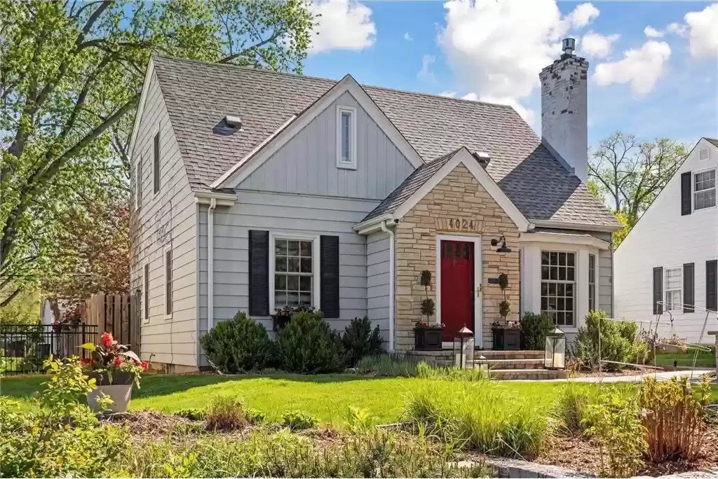 A beautiful two-story house with a stone facade and vibrant landscaping.