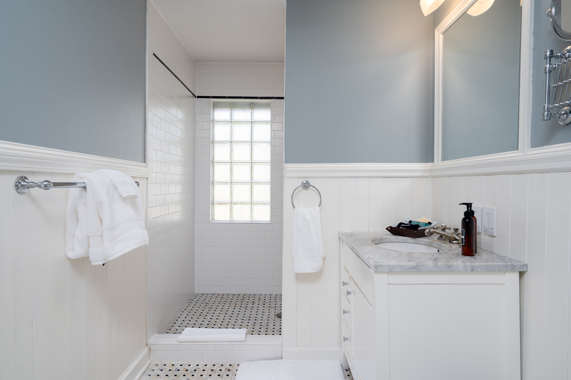 A serene bathroom featuring a modern design with a blue accent wall and white fixtures.