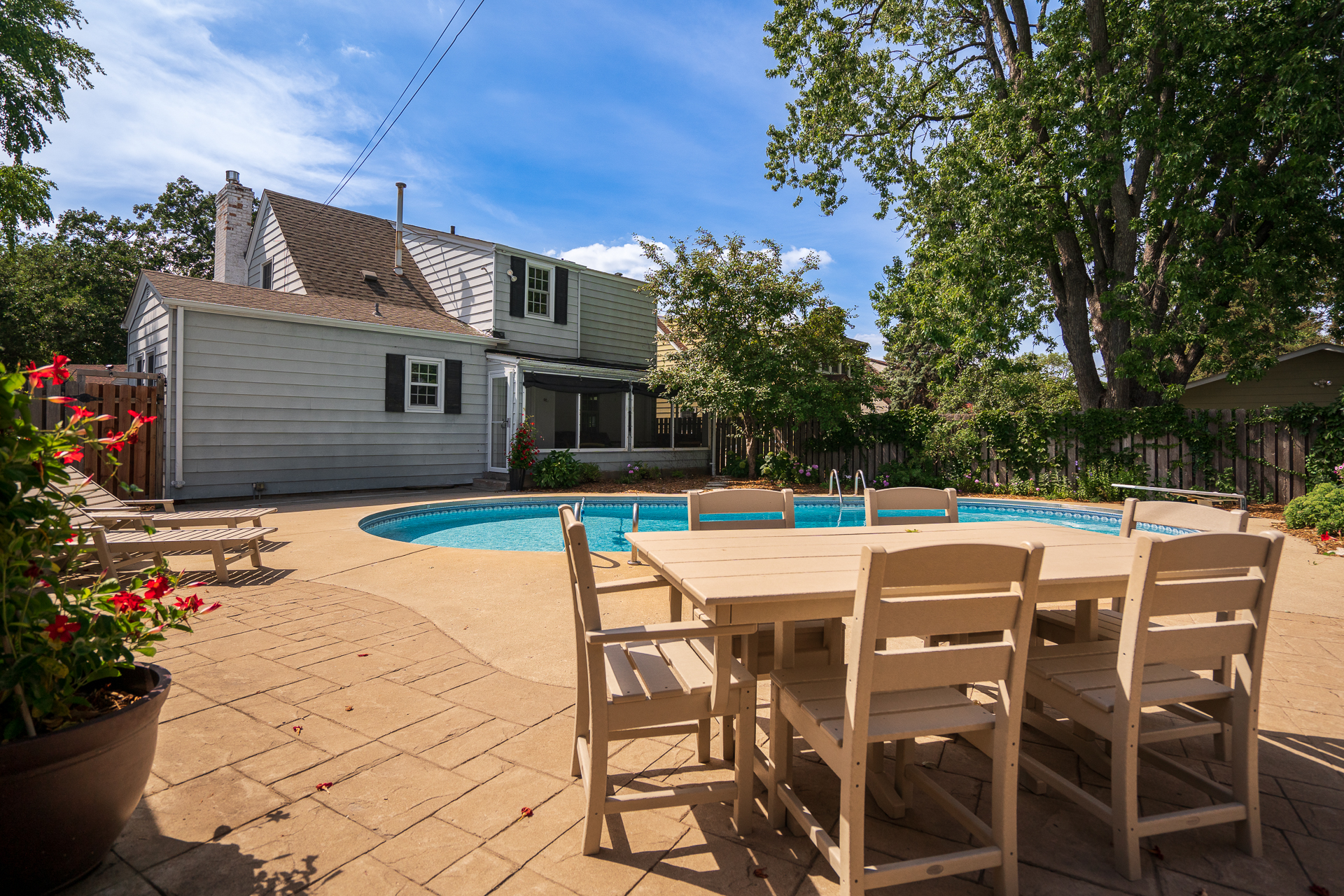 A charming backyard with a swimming pool and outdoor dining area.