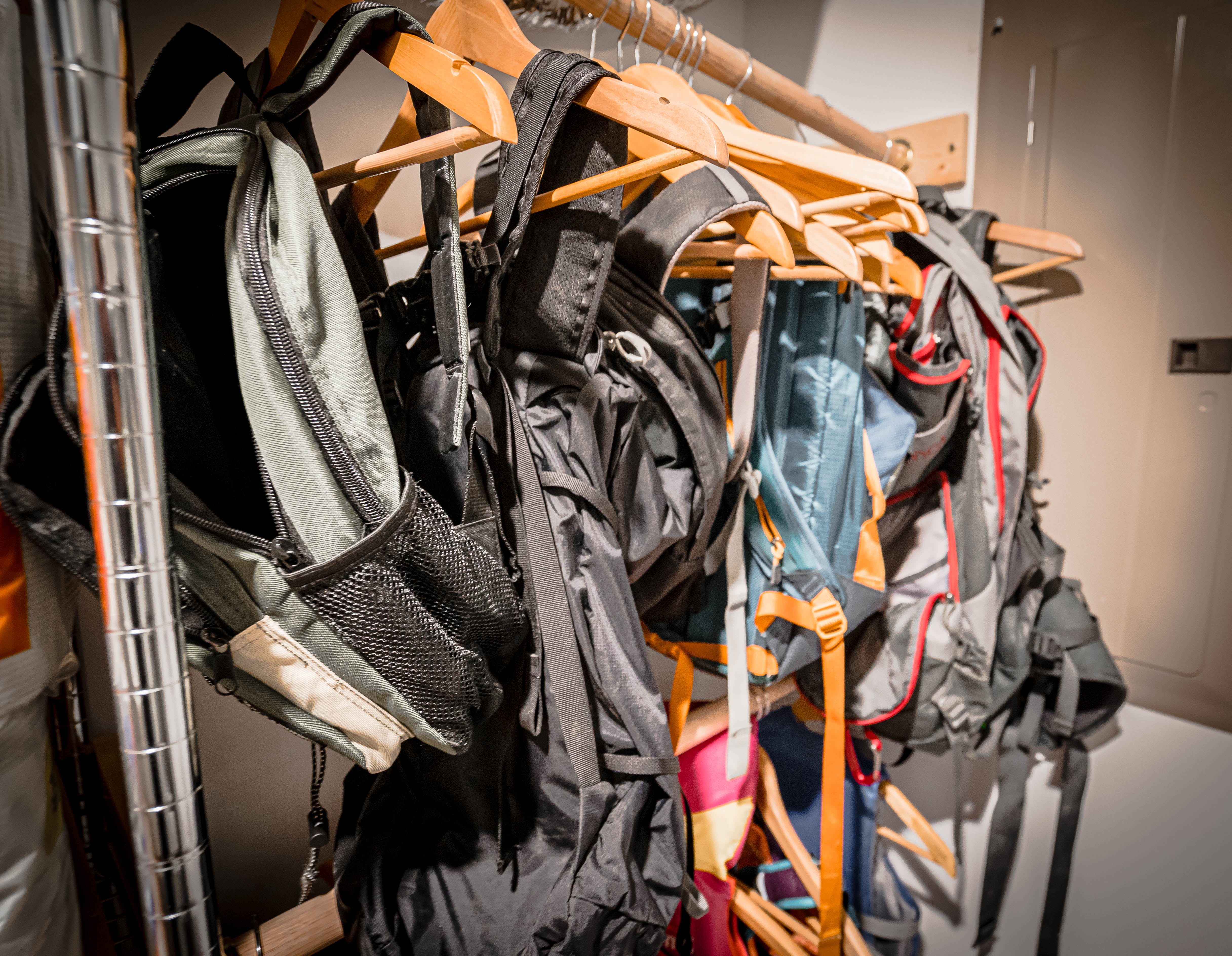 A collection of diverse backpacks hanging neatly, showcasing their varying designs and colors.