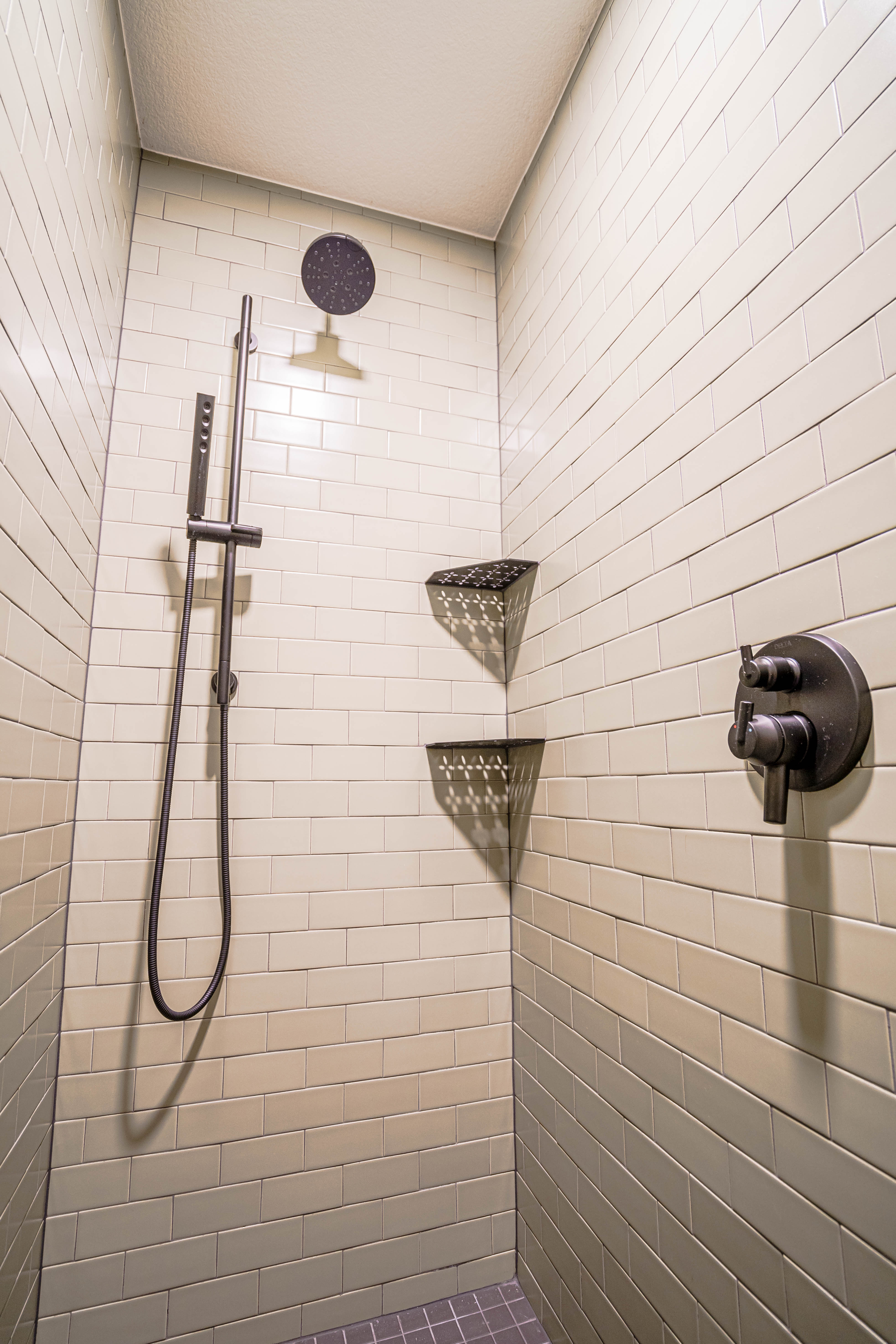 Stylish modern shower with light subway tiles and sleek fixtures.