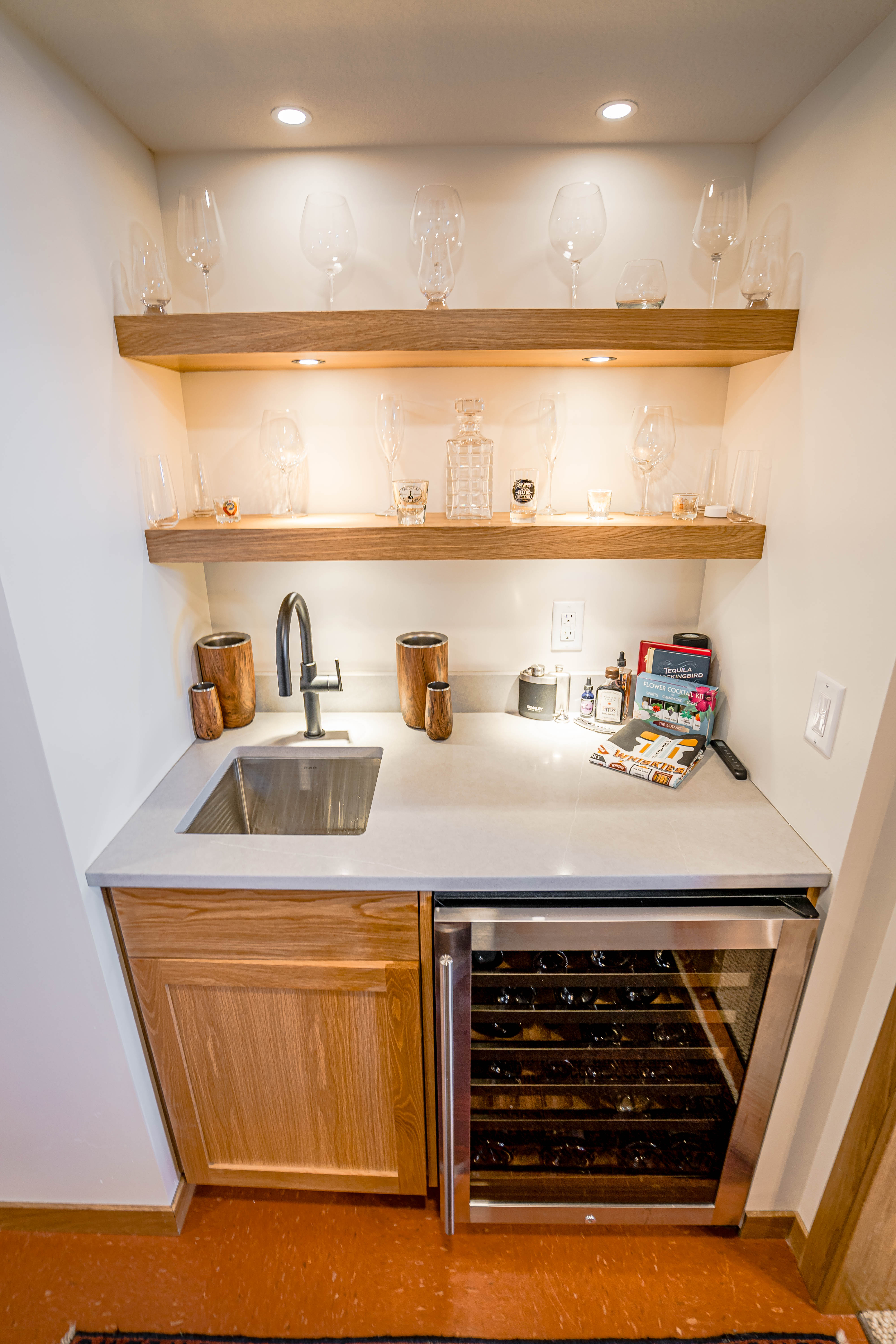 Modern wet bar featuring elegant glassware and a wine cooler.