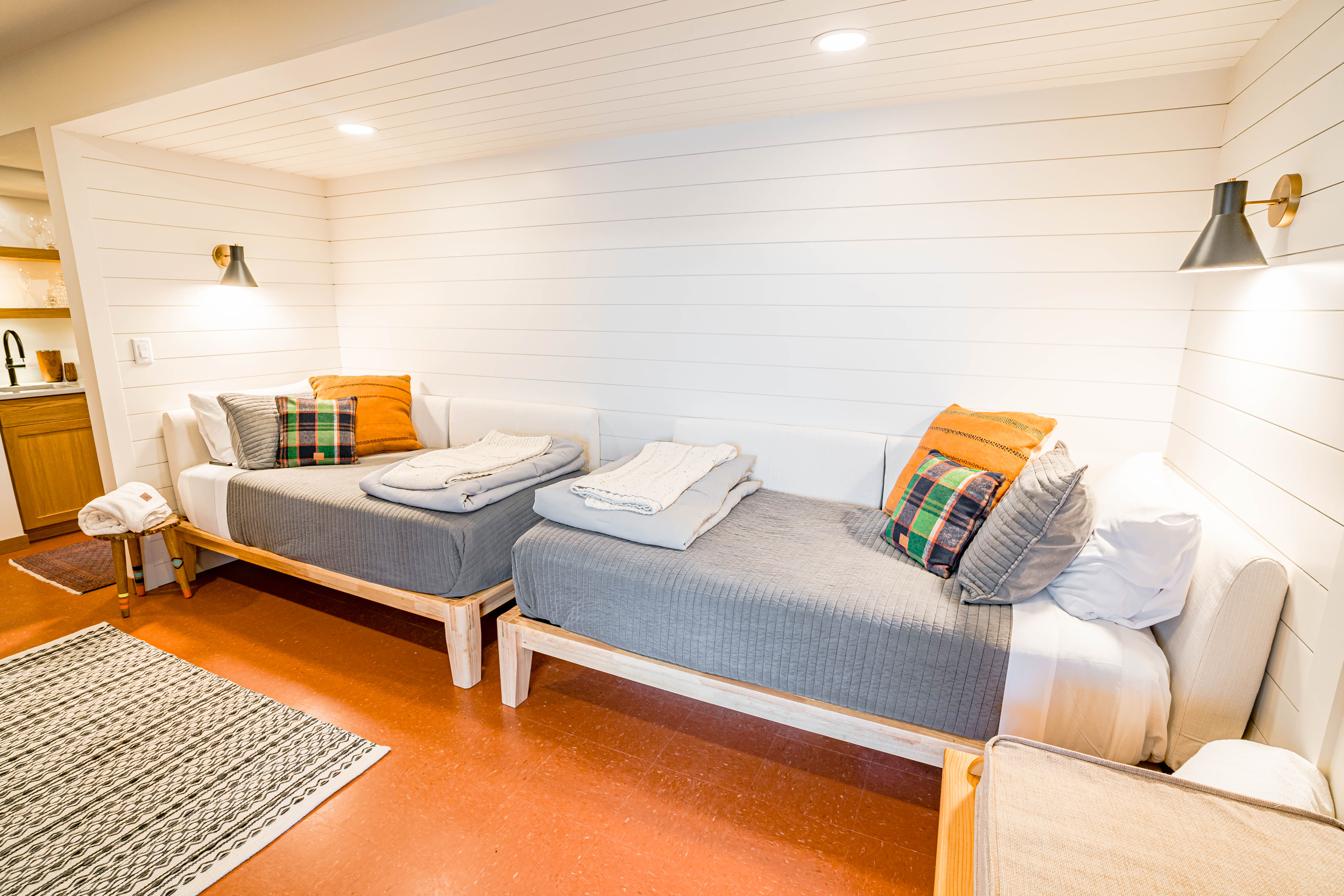 A cozy and inviting minimalist bedroom with twin beds and warm decor.