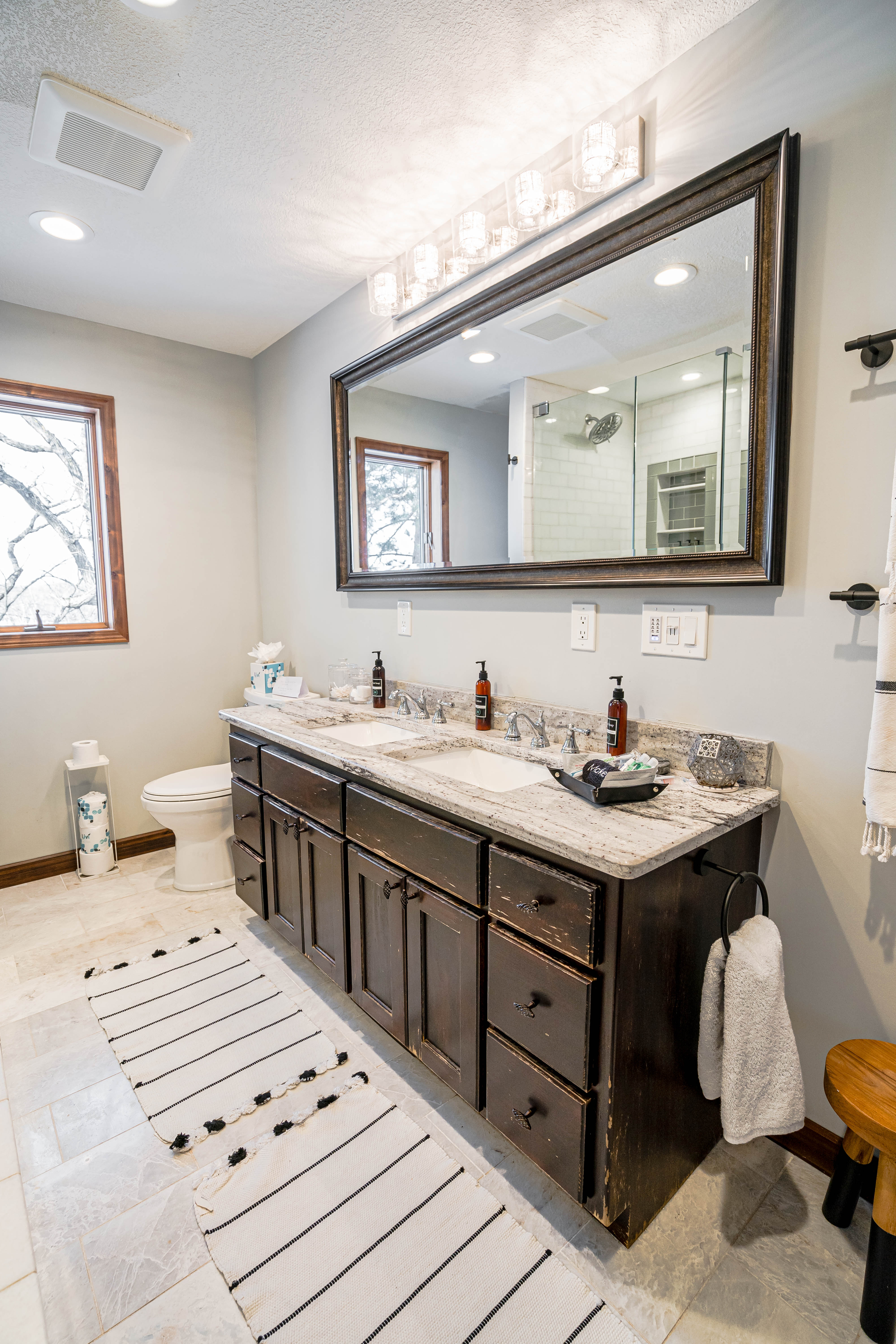 A stylish modern bathroom with rustic cabinetry and elegant fixtures.
