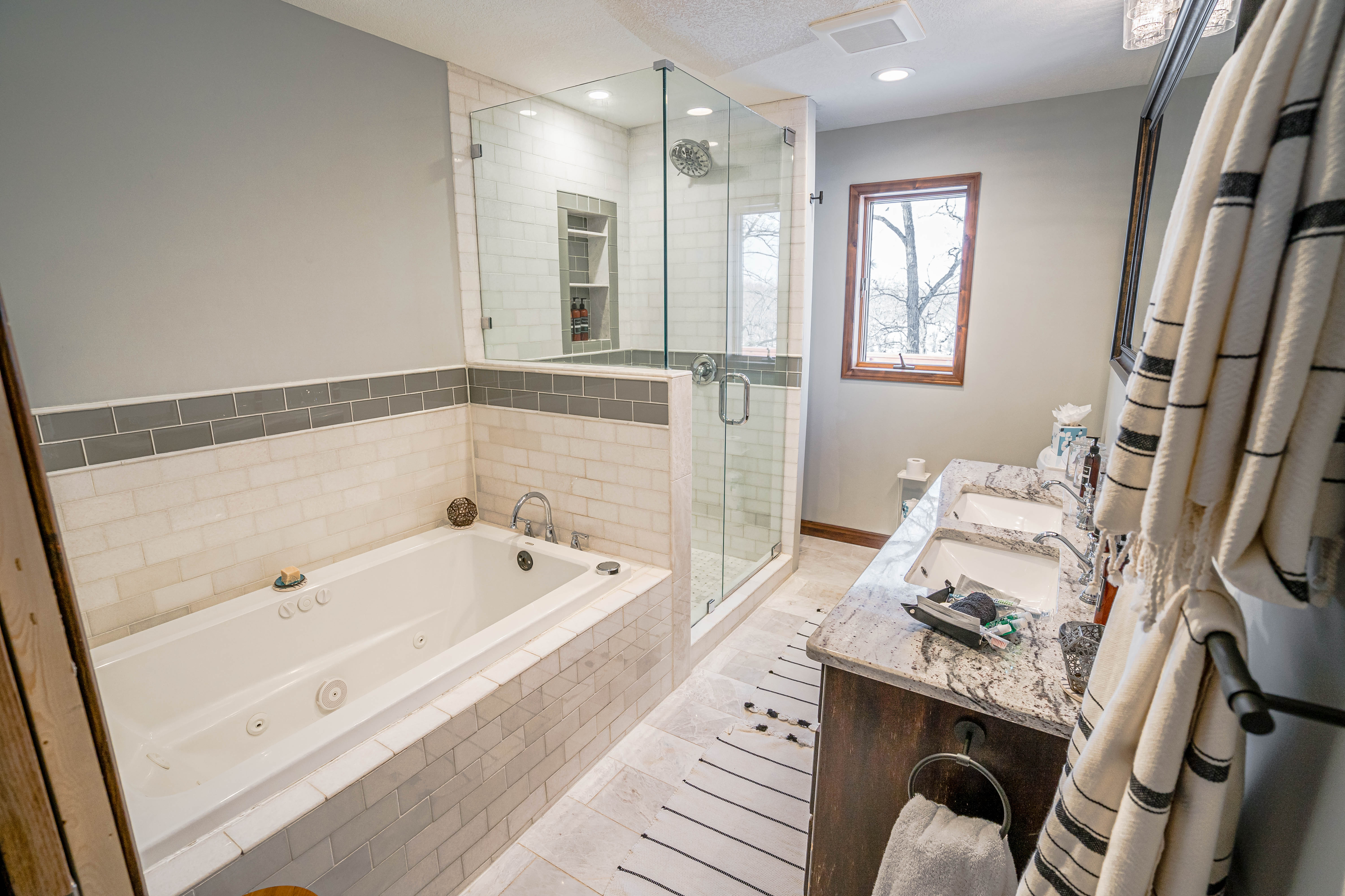 A modern bathroom featuring a jacuzzi tub, walk-in shower, and elegant double vanity.