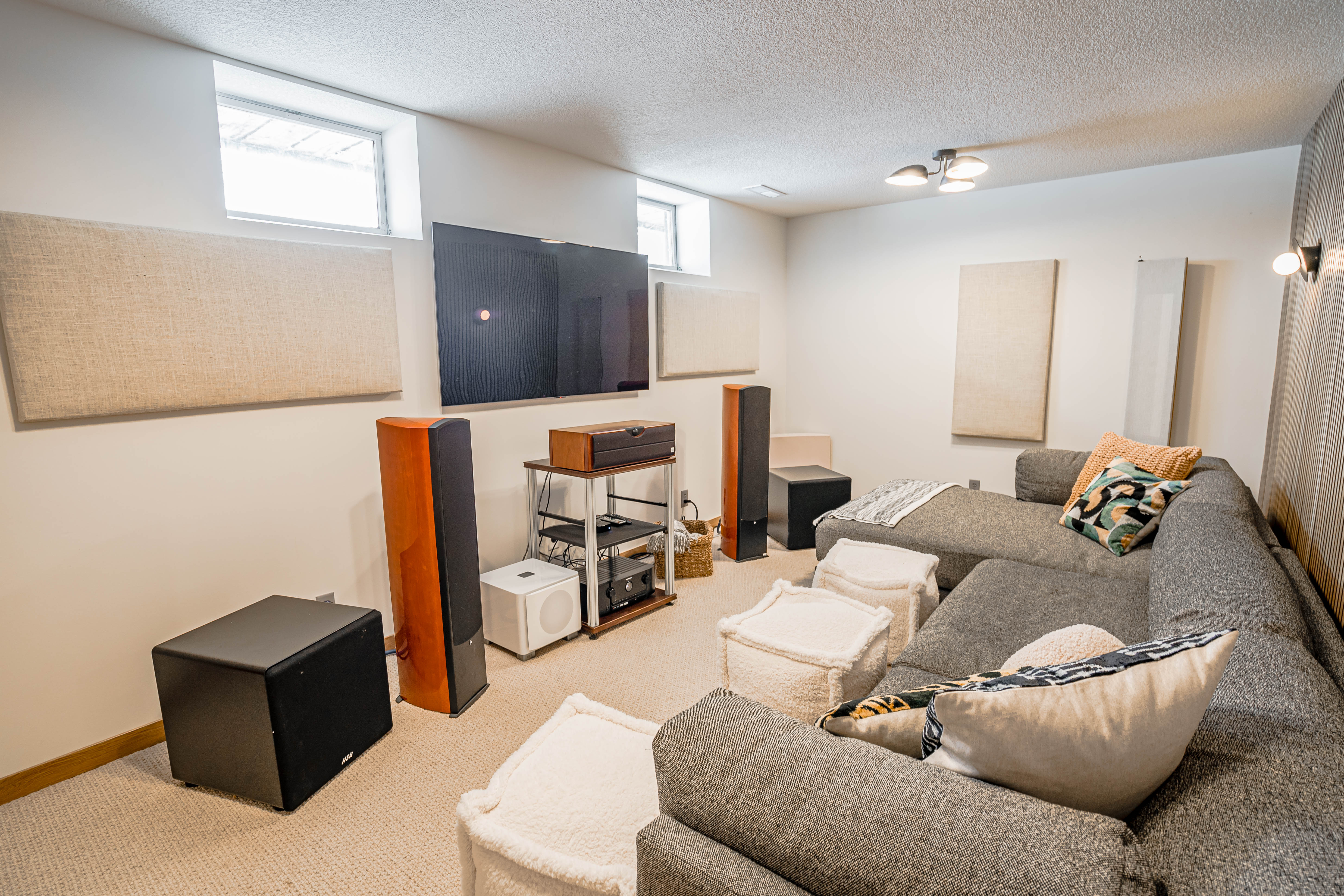A modern home theater setup featuring a gray sectional sofa and sleek audio equipment.