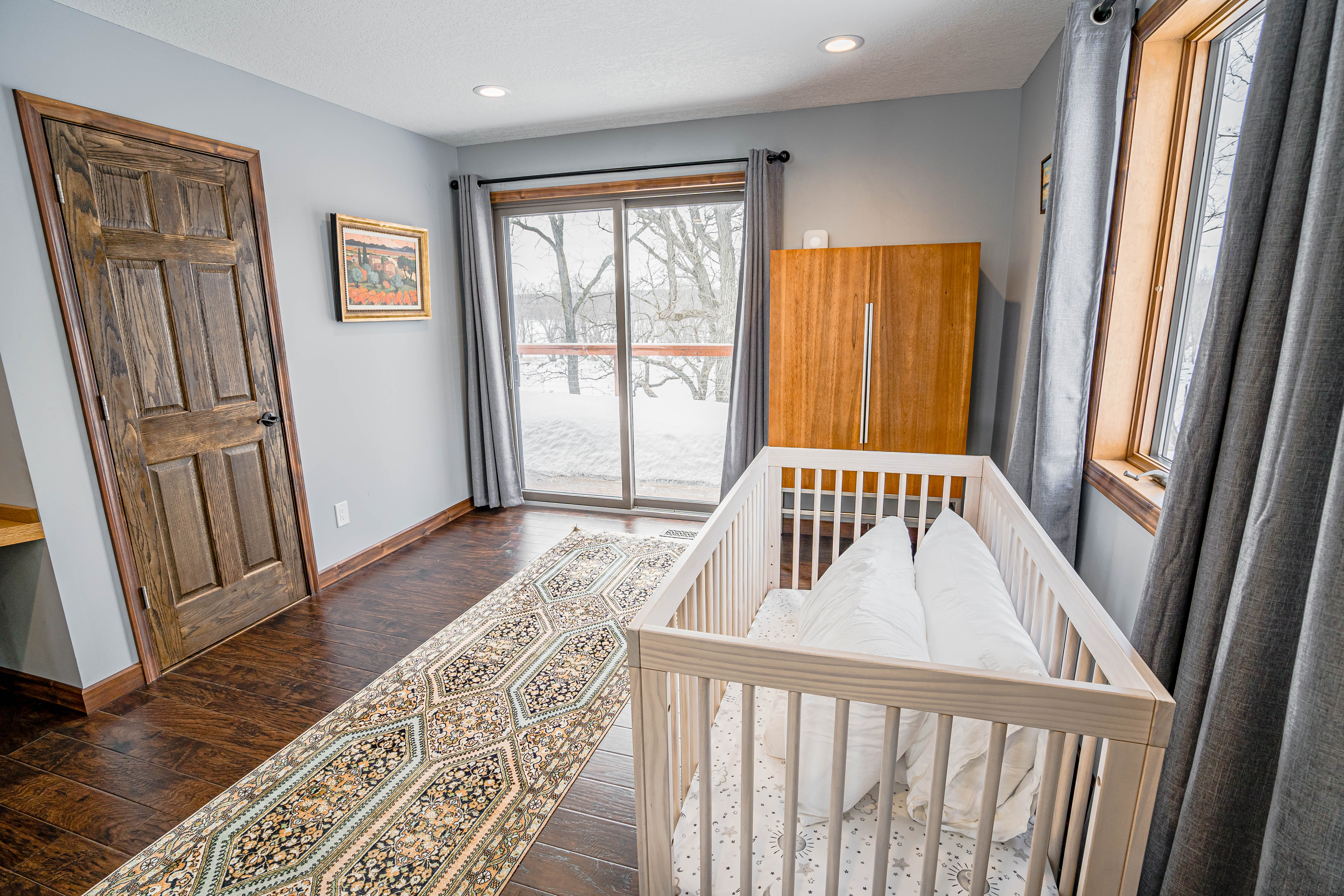 A serene nursery with a contemporary design featuring a crib and natural light.
