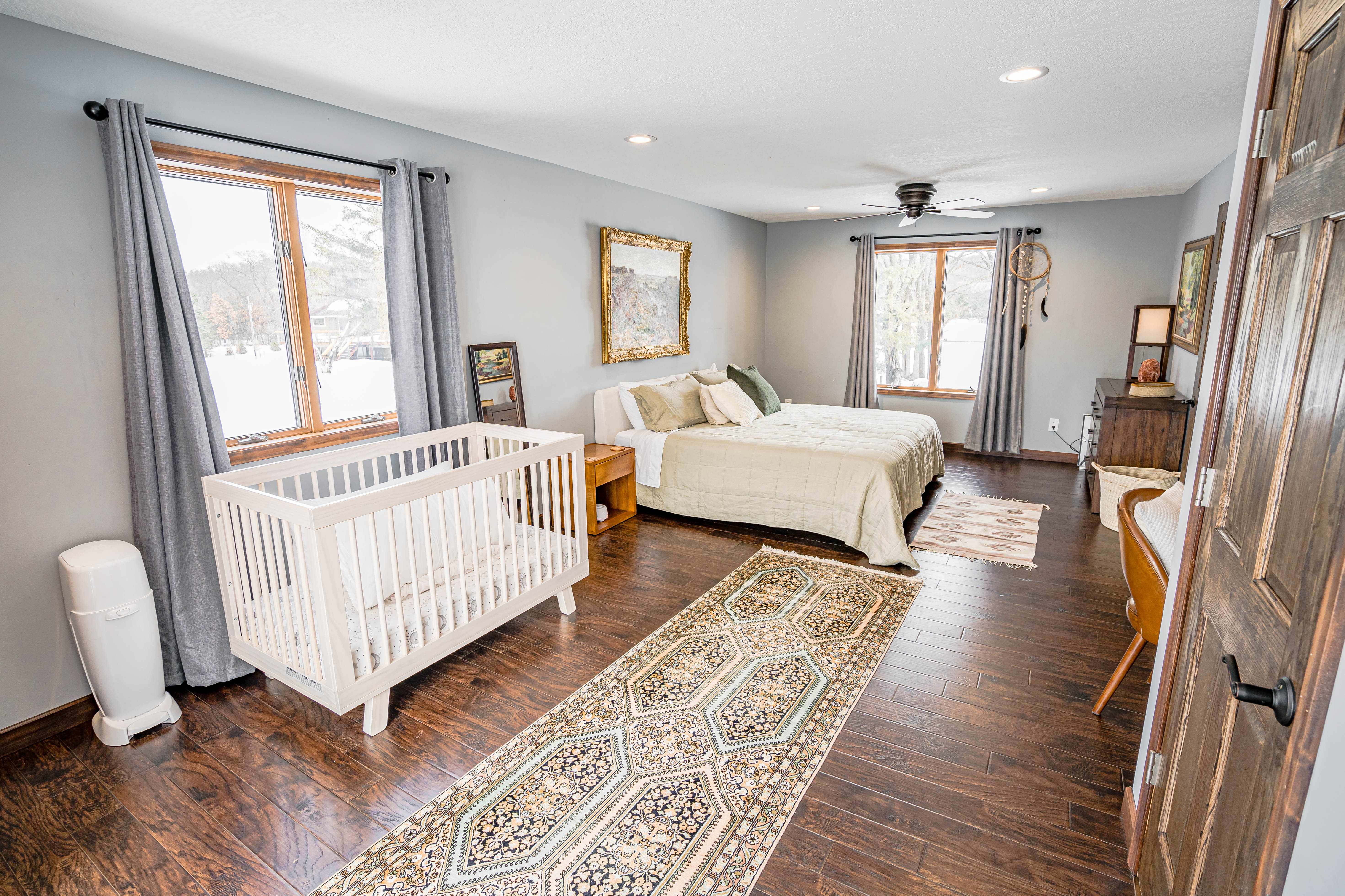 A cozy and stylish bedroom featuring a crib and a comfortable bed.