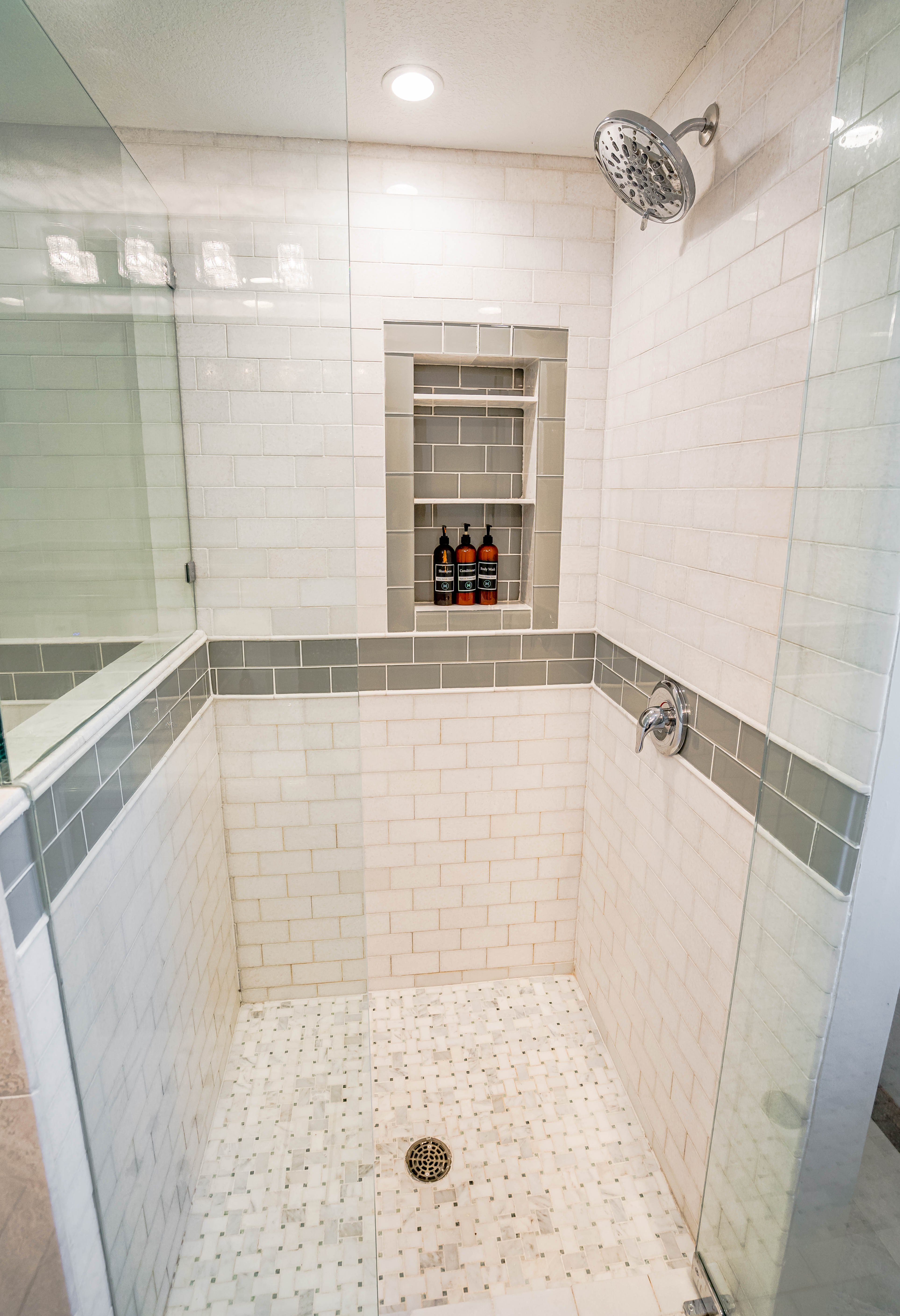 A modern shower with sleek design elements and organized storage for toiletries.