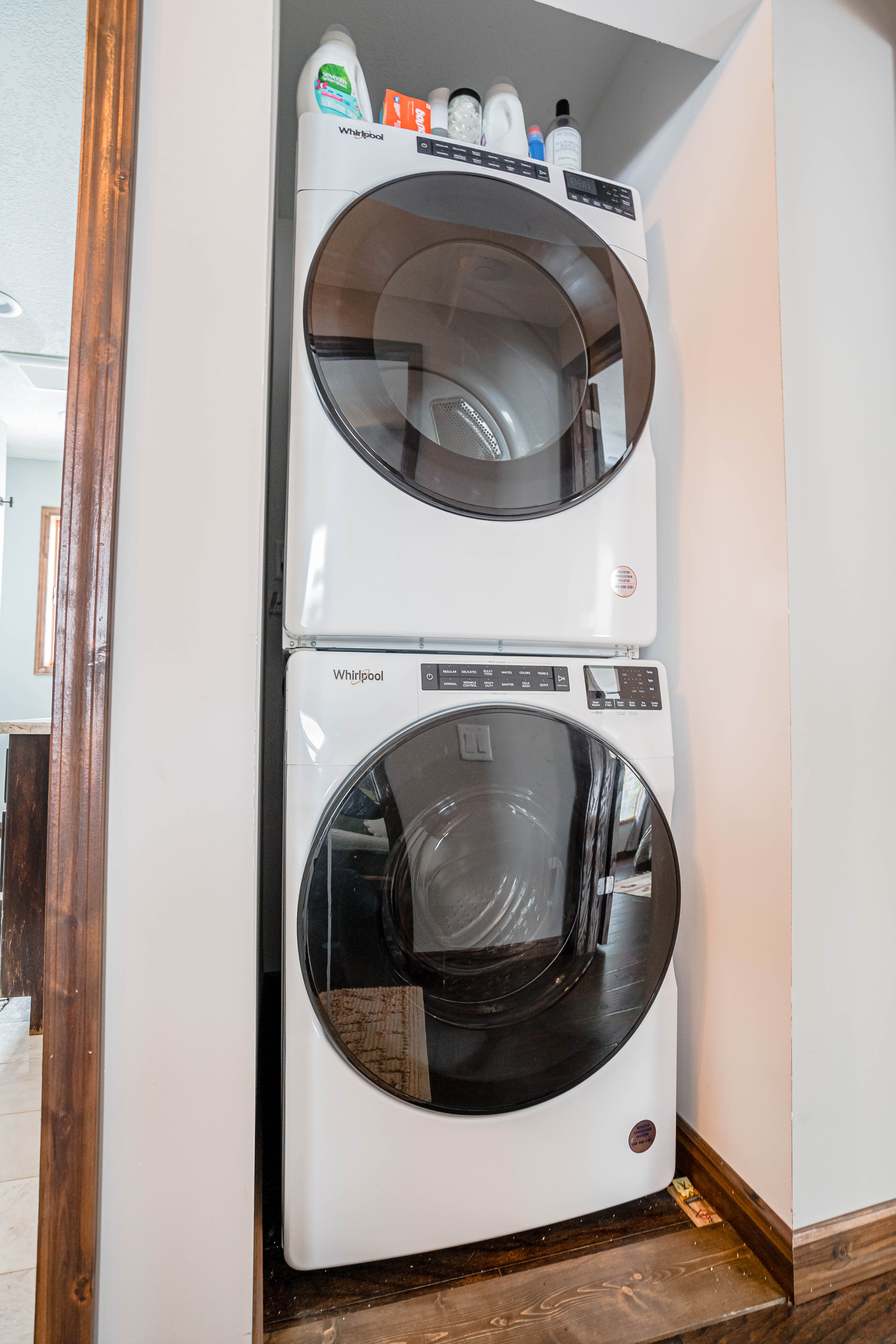 Modern stacked Whirlpool laundry machines in a cozy laundry corner.