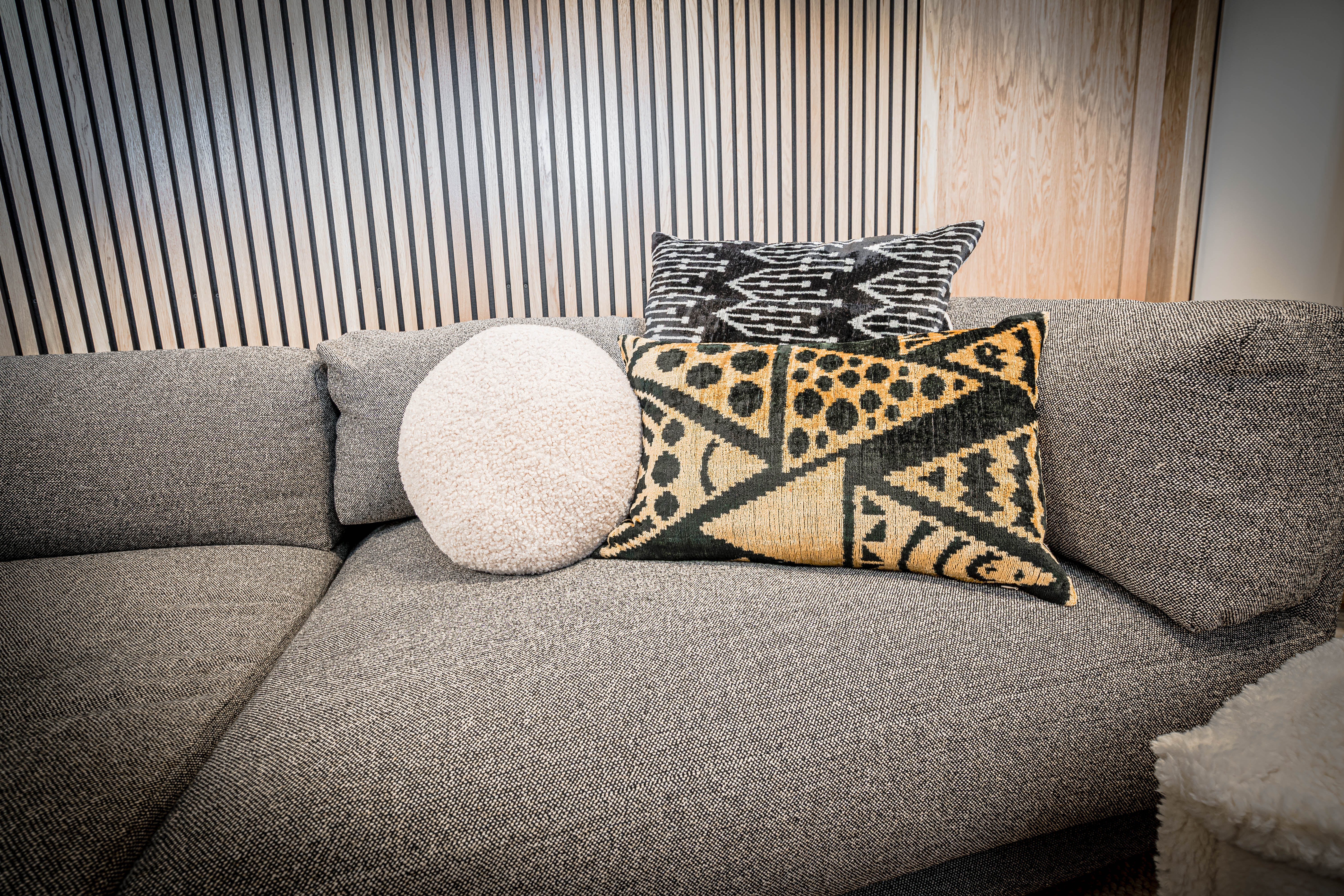 A modern gray sofa adorned with decorative pillows in a cozy living room setting.