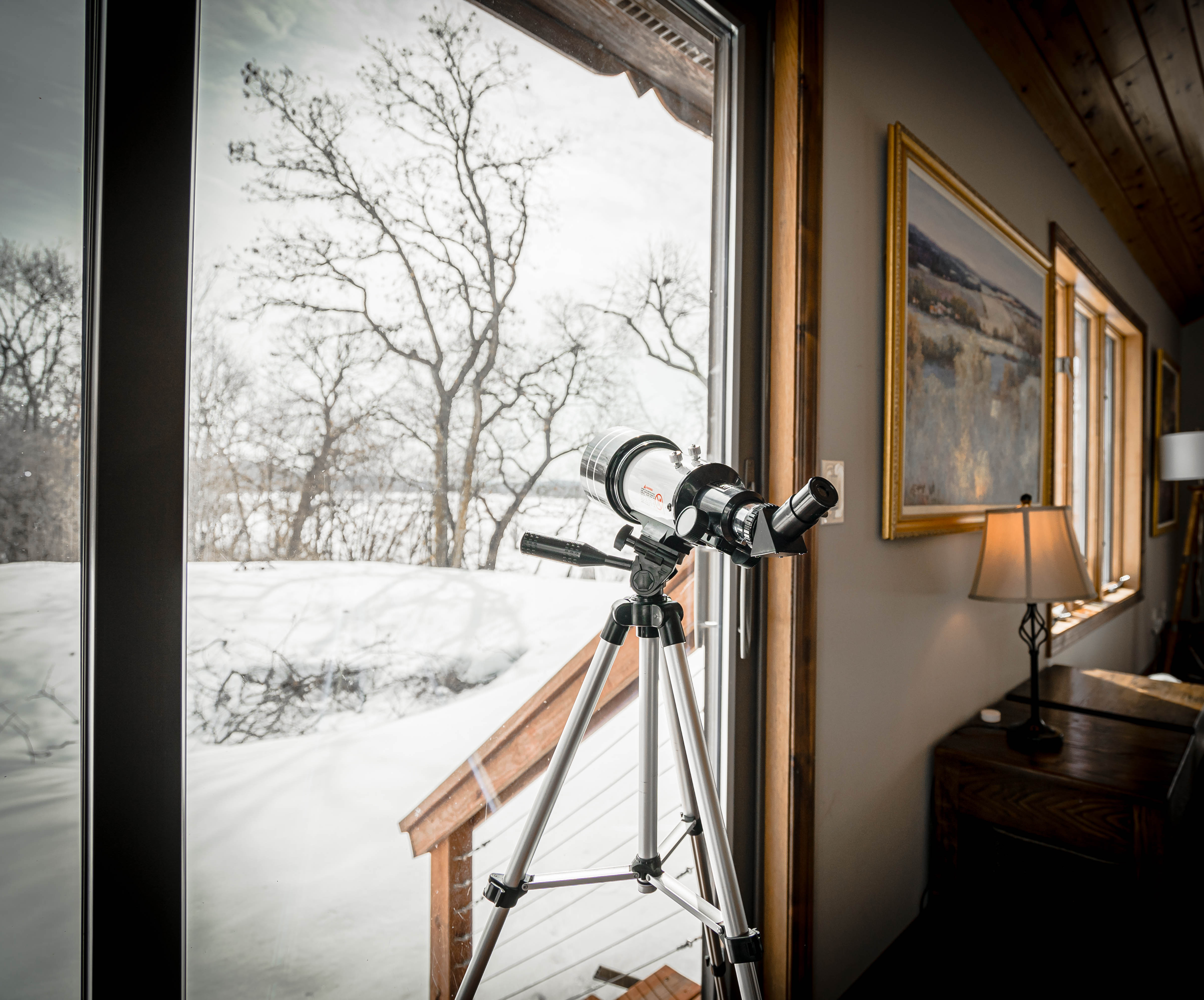A telescope view of winter through a cozy cabin window.