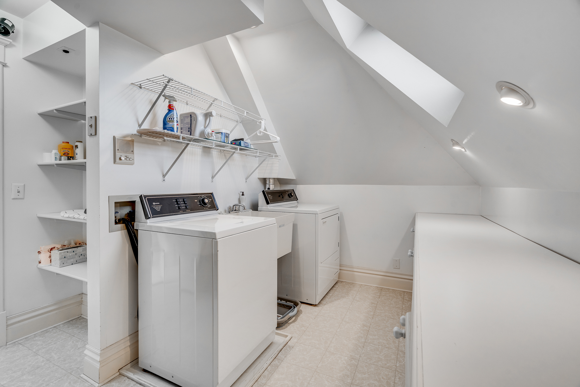 Bright and organized attic laundry room with modern appliances.