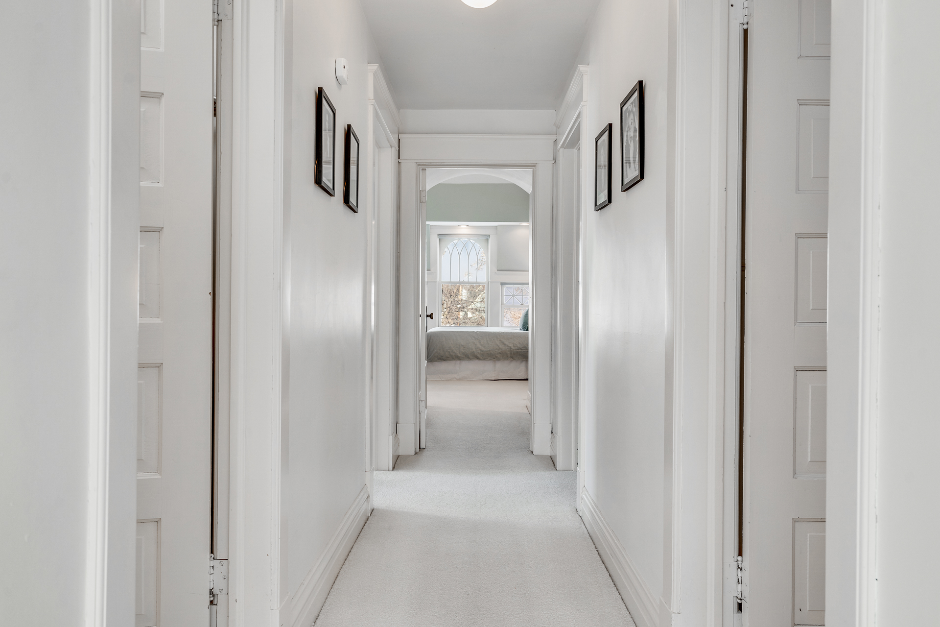 A bright and inviting hallway leading to a cozy bedroom.