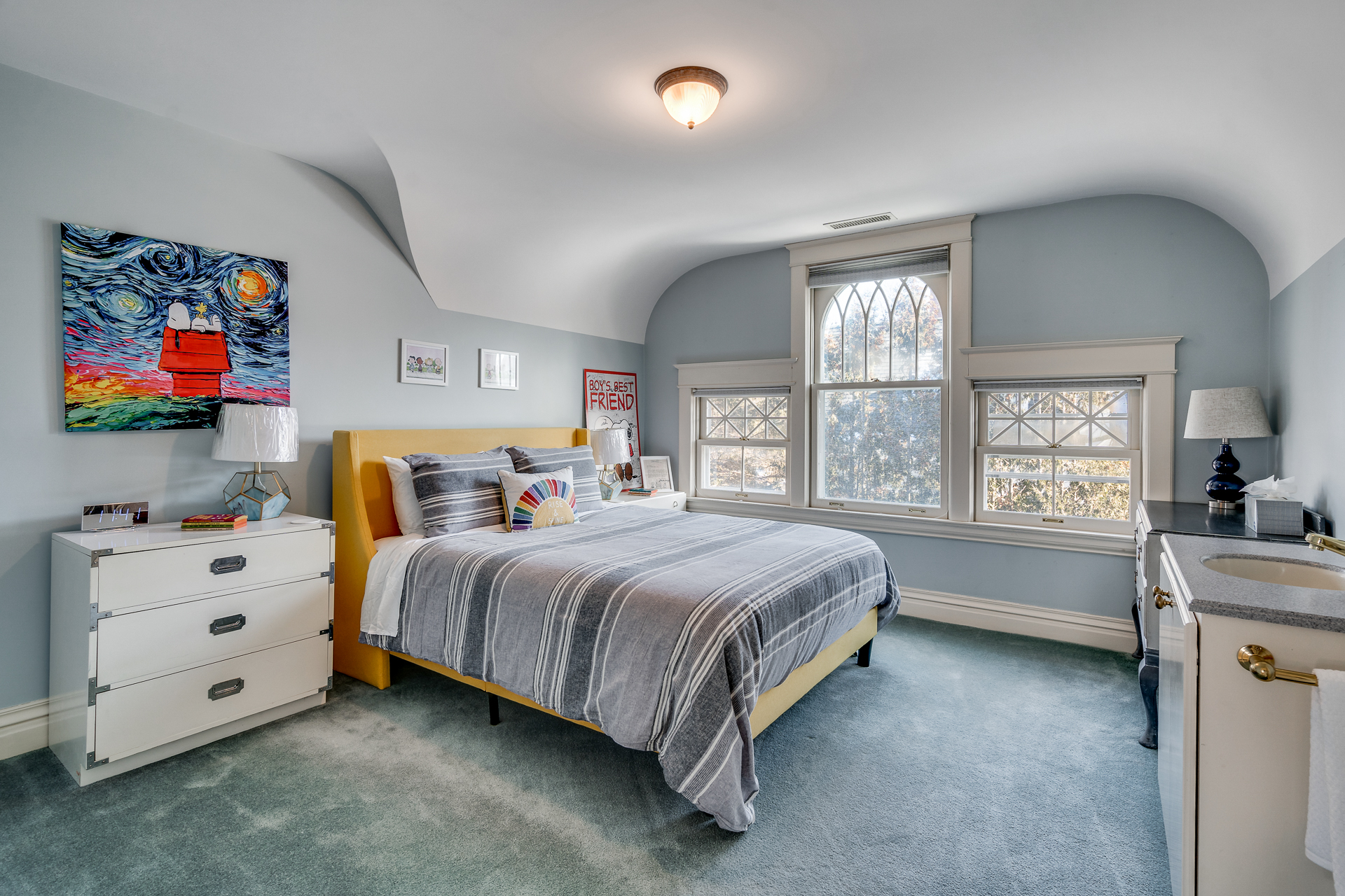 A bright and cozy bedroom with modern decor and artistic touches.
