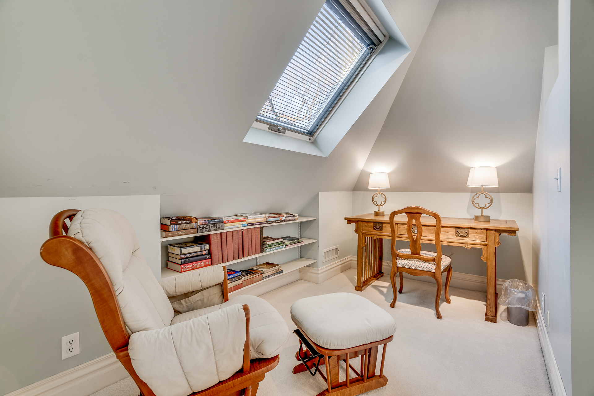 A serene reading and workspace in a cozy nook under a sloped roof.