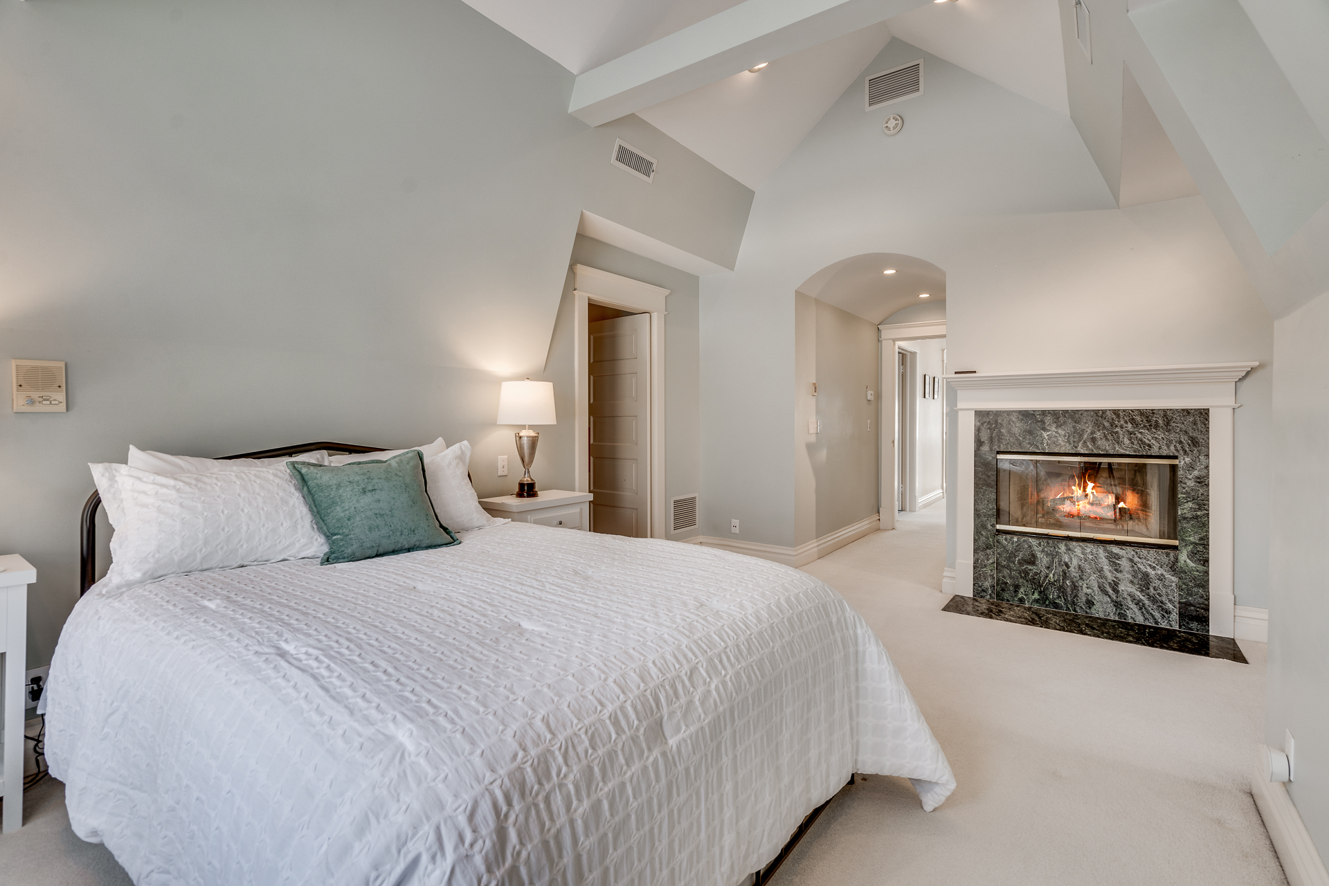 Cozy and elegant bedroom featuring a modern fireplace and chic decor.