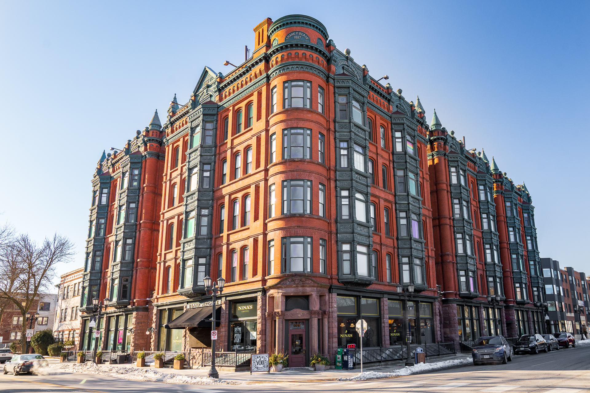 A historic building showcasing vibrant red brick and ornate architecture in a bustling urban landscape.