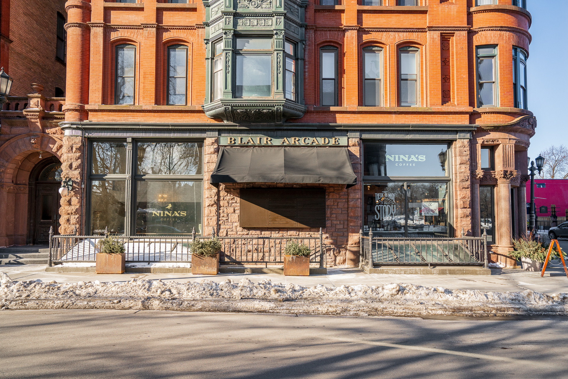 A charming corner building featuring Nina's Coffee and Blair Arcade.