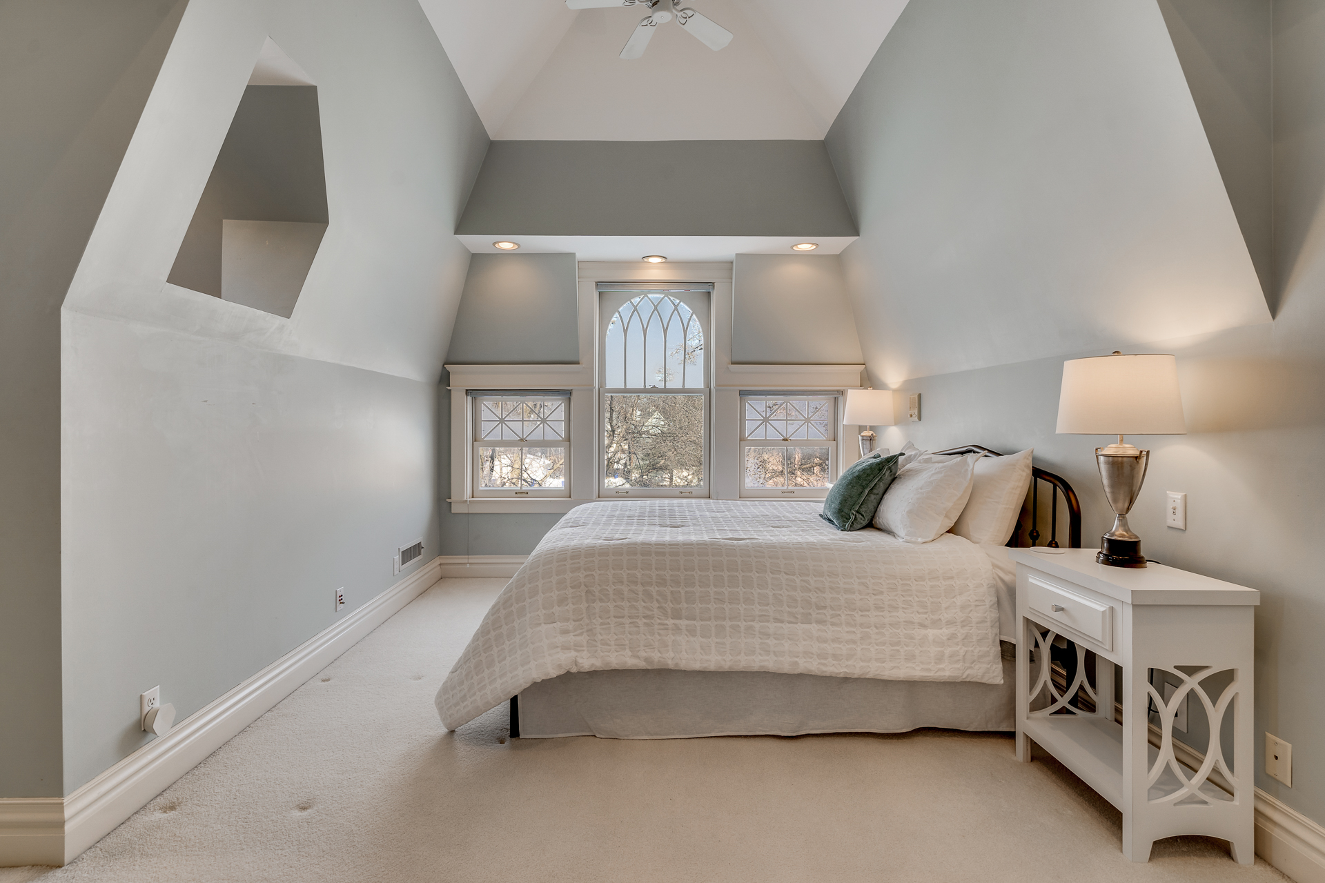 Cozy bedroom with sloped ceiling and soft lighting.