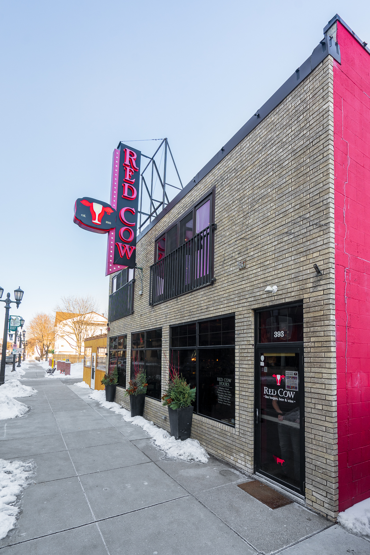 The inviting exterior of Red Cow, showcasing its vibrant signage and winter surroundings.