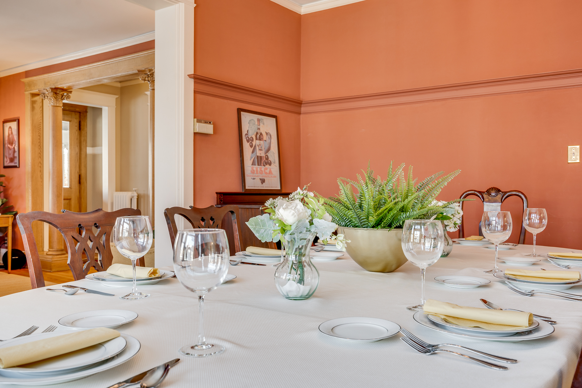 Elegant dining table set with fine china and floral centerpiece.