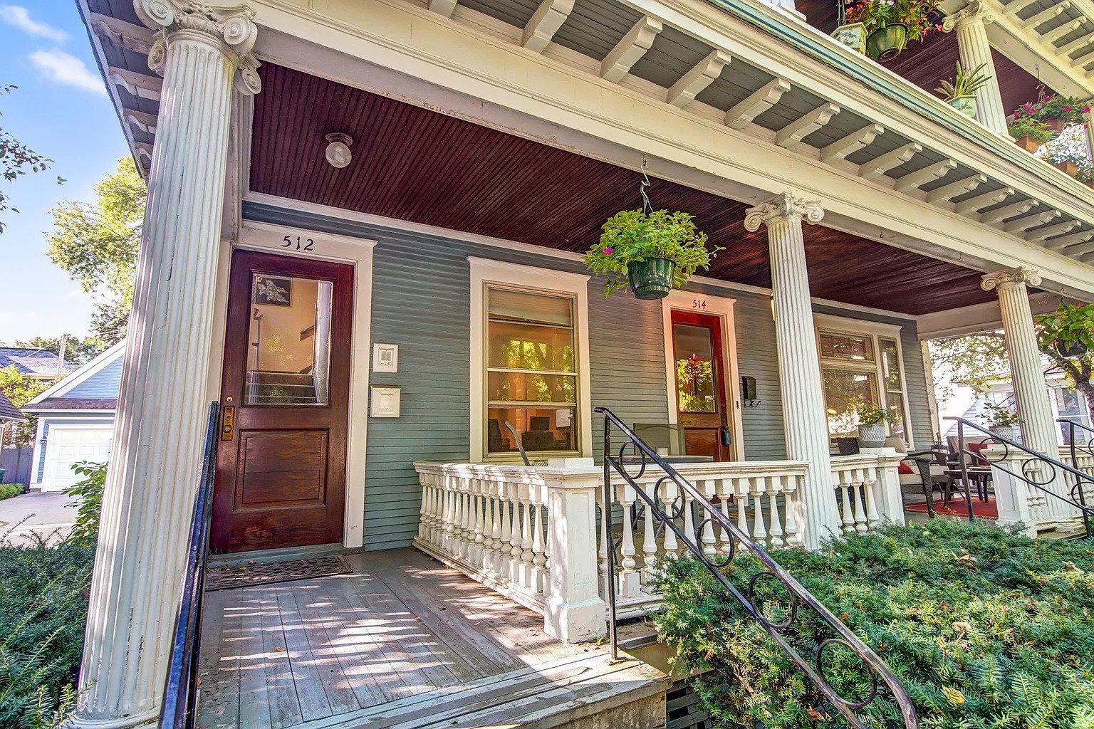 Charming entrance of a historic duplex with vibrant plants and welcoming design.