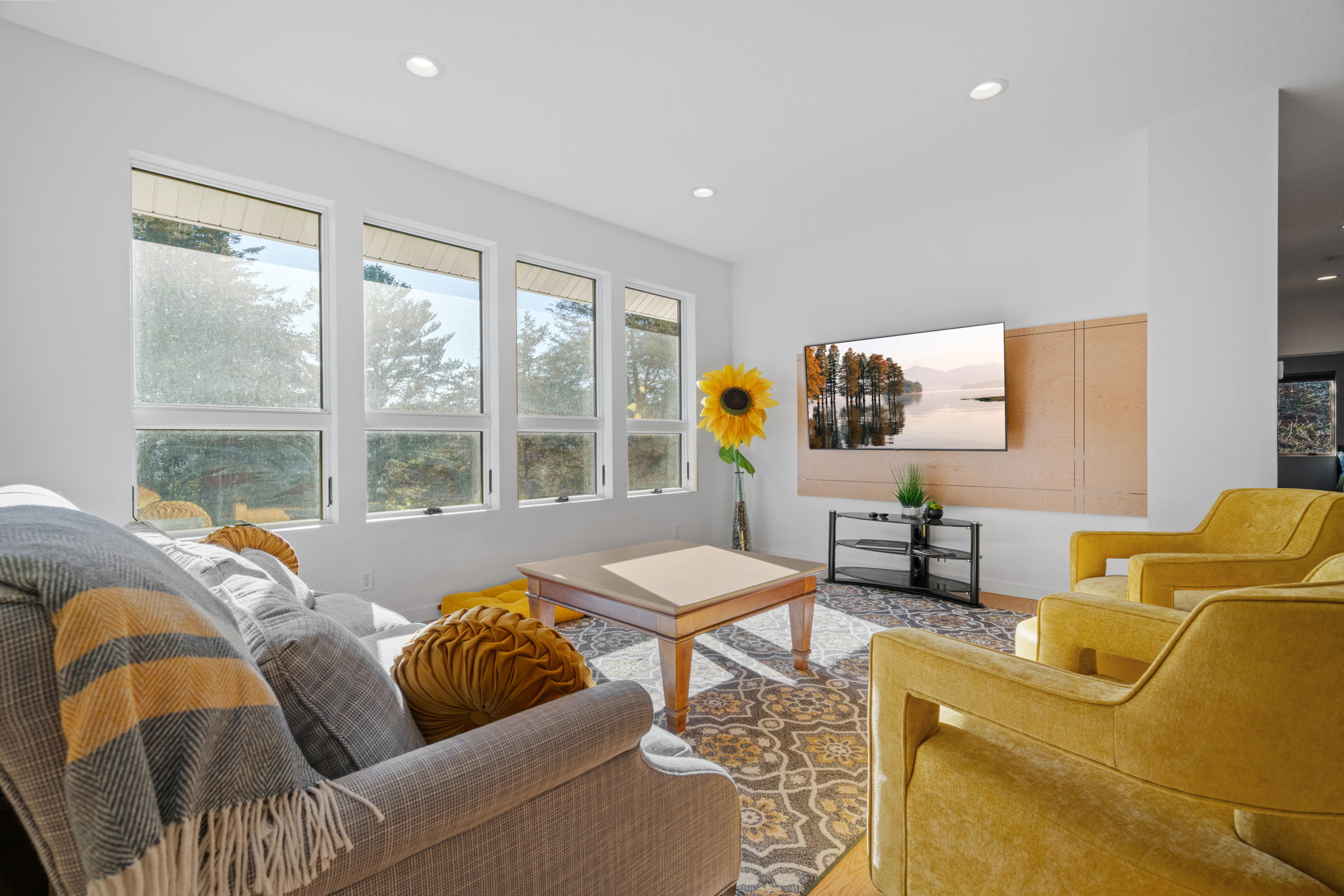 A modern living room bathed in natural light, featuring vibrant decor and cozy furniture.