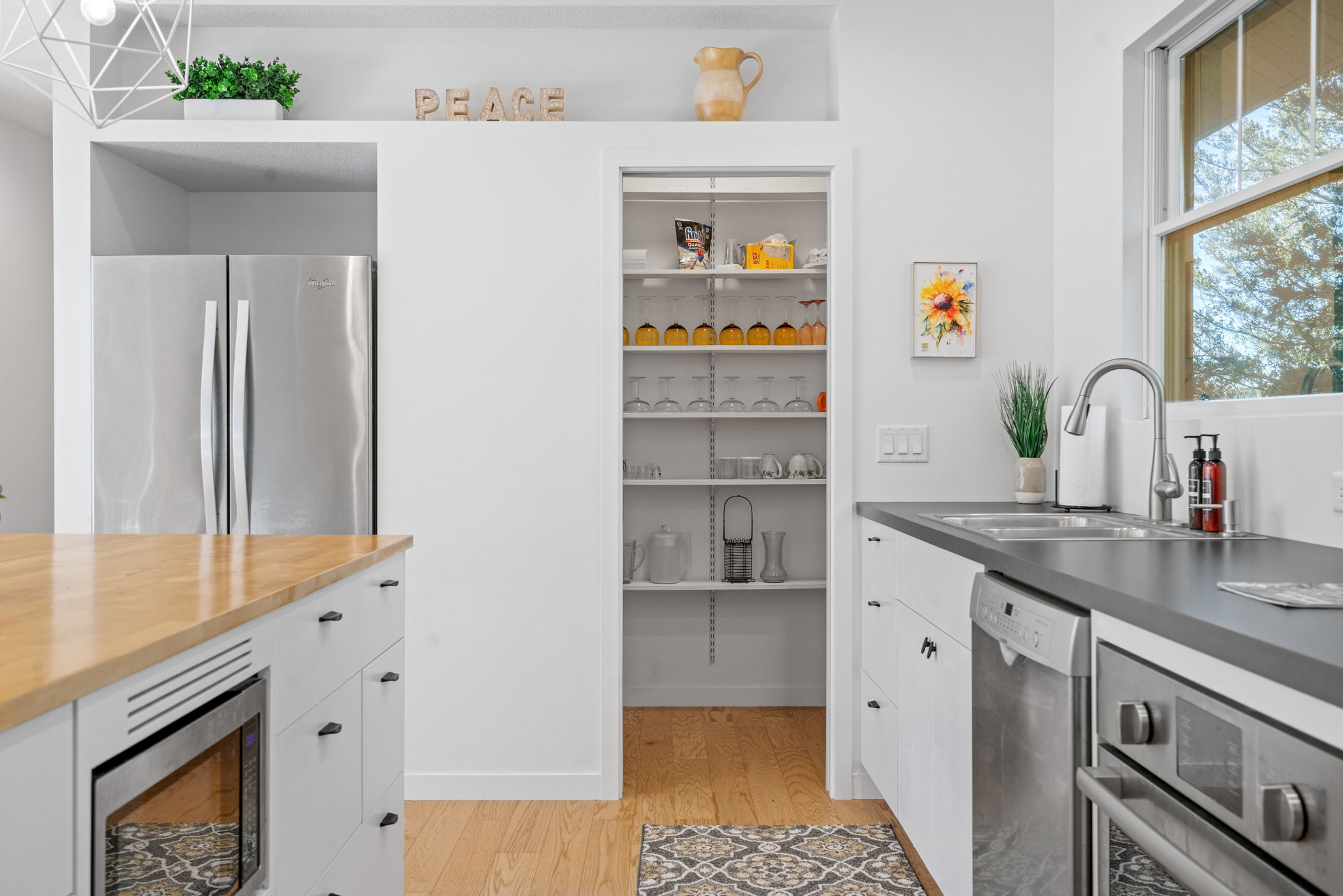 A bright and airy modern kitchen with elegant design elements and organized pantry.
