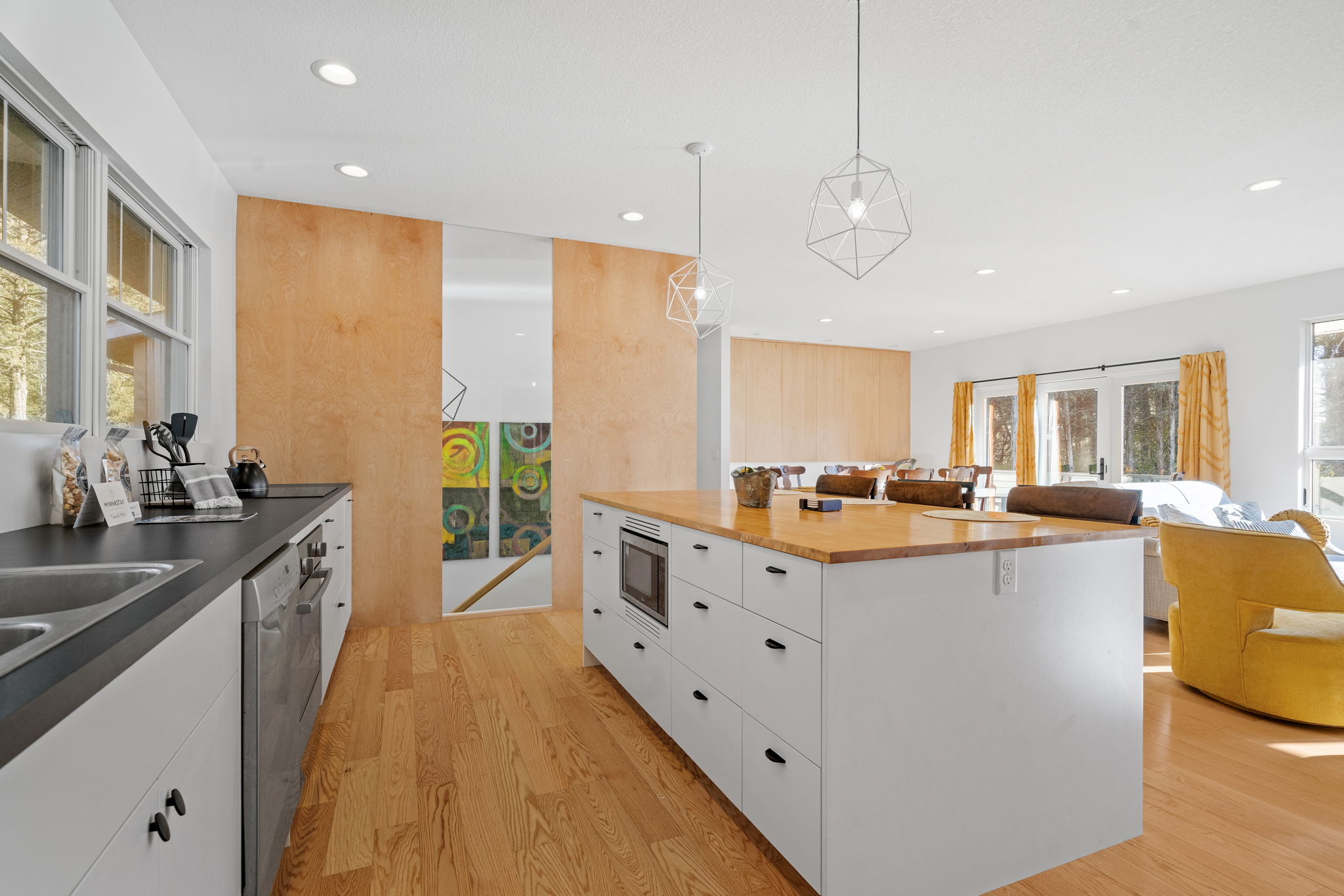 A bright and modern kitchen with sleek design and a cozy living area in view.
