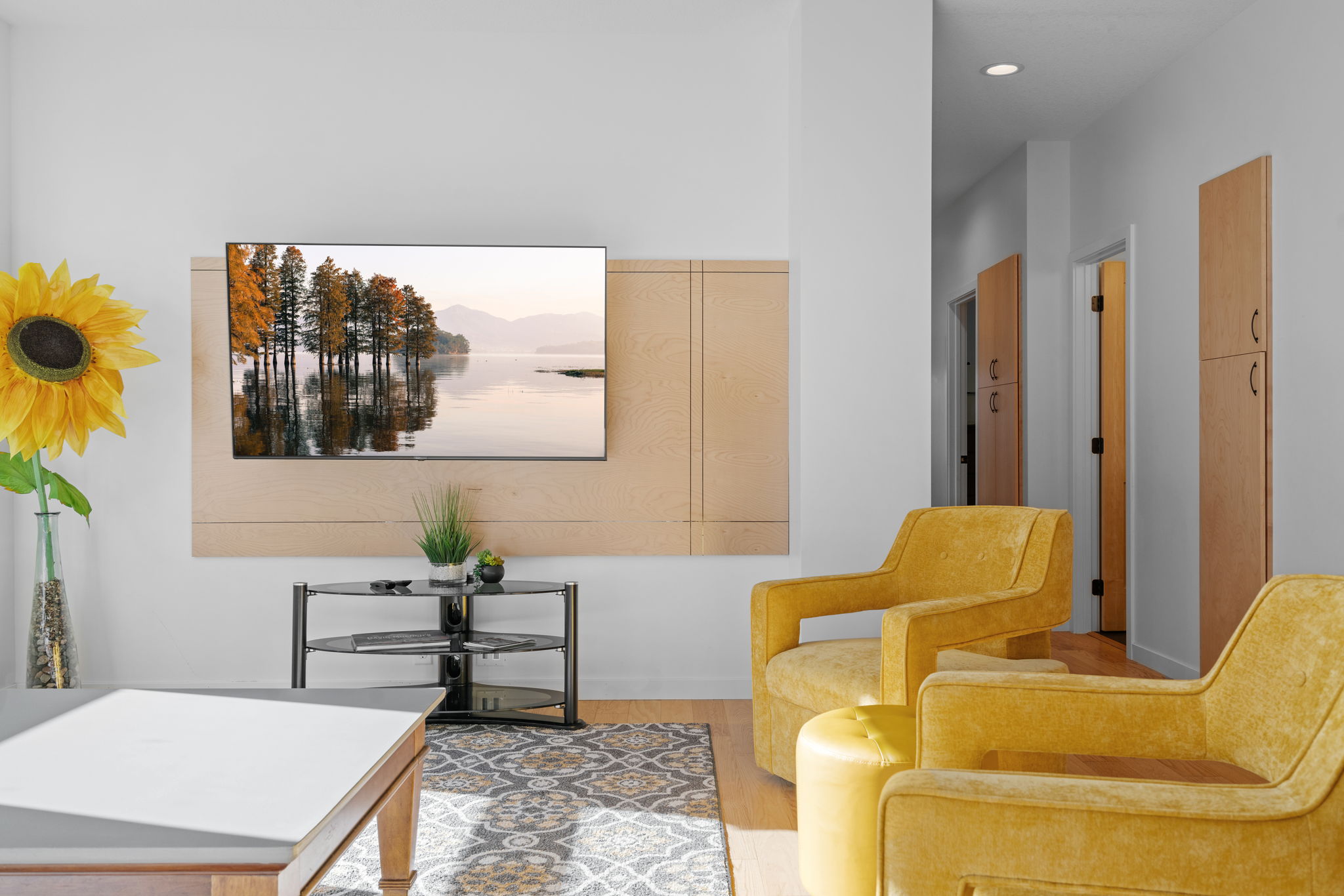 A contemporary living room featuring a serene TV display and vibrant decor.