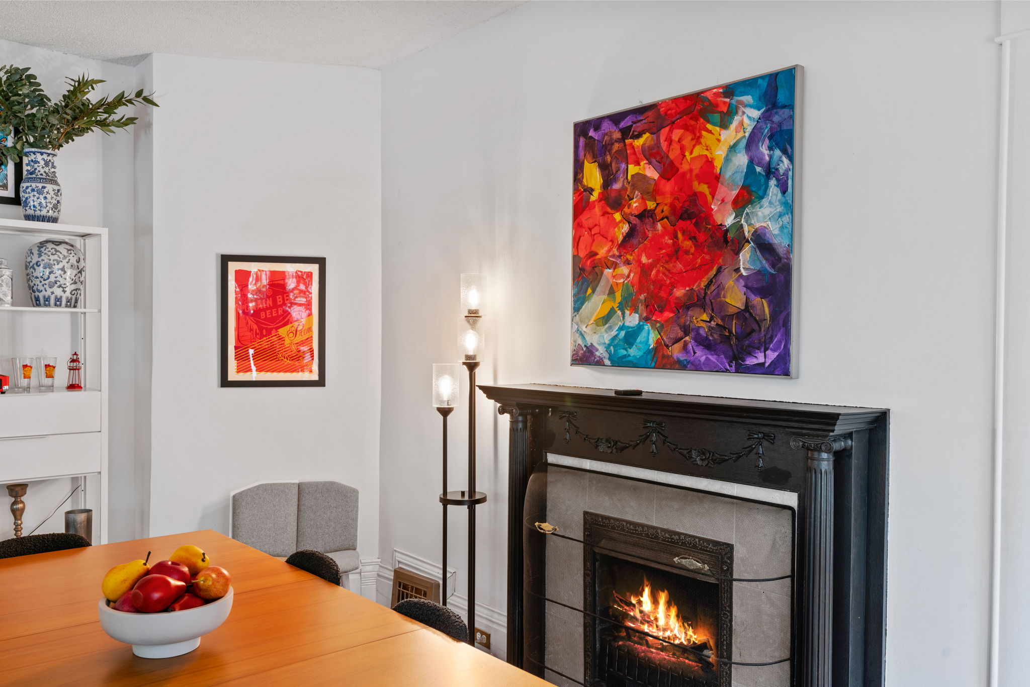 A vibrant dining area with a cozy fireplace and colorful artwork.