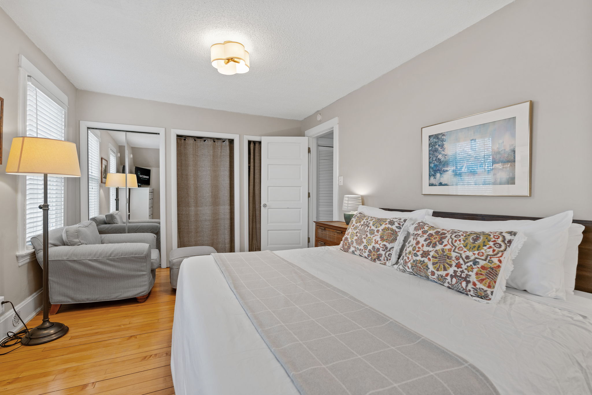 A cozy and inviting bedroom featuring a large bed and comfortable seating area.
