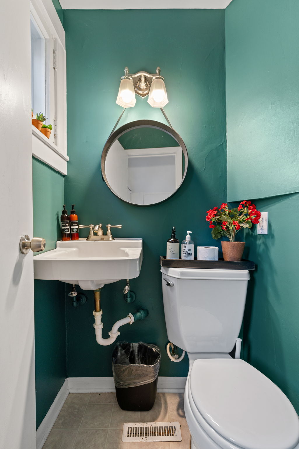 A modern and stylish bathroom with teal walls and elegant fixtures.