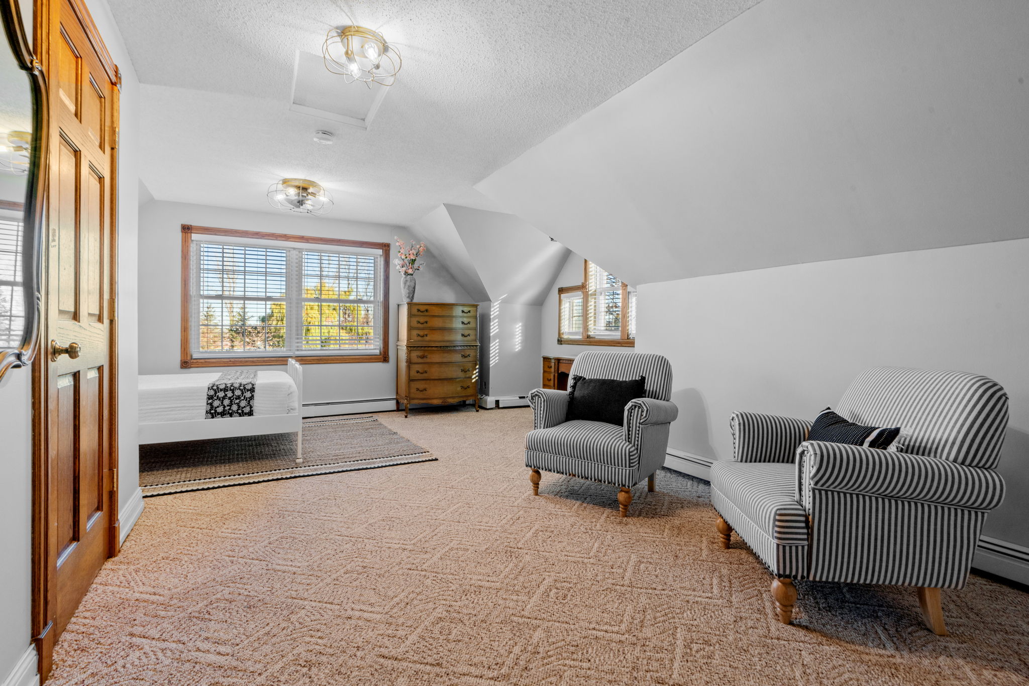 A bright and cozy attic bedroom with stylish furnishings.