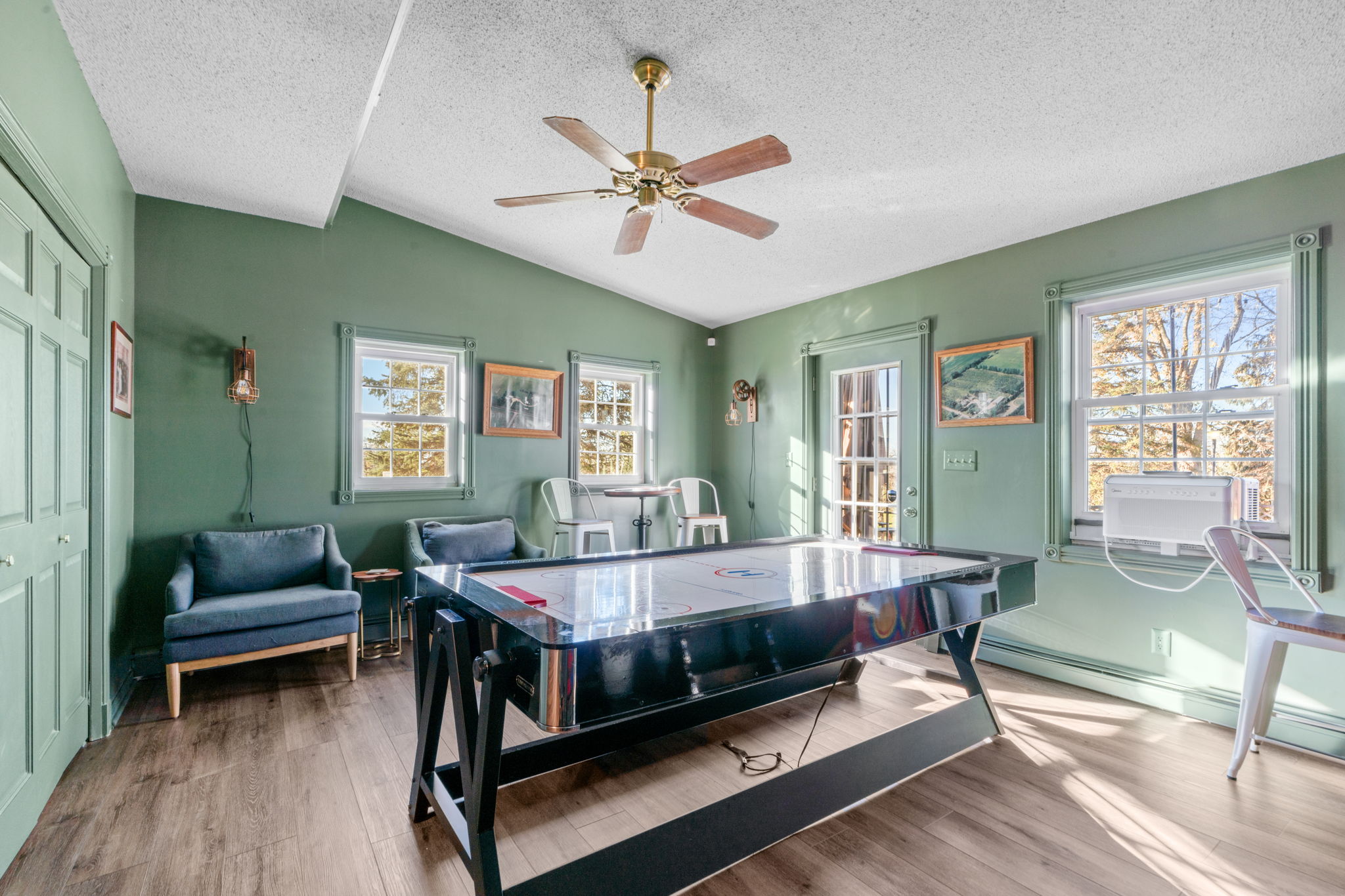 A cozy game room with an air hockey table and stylish seating.
