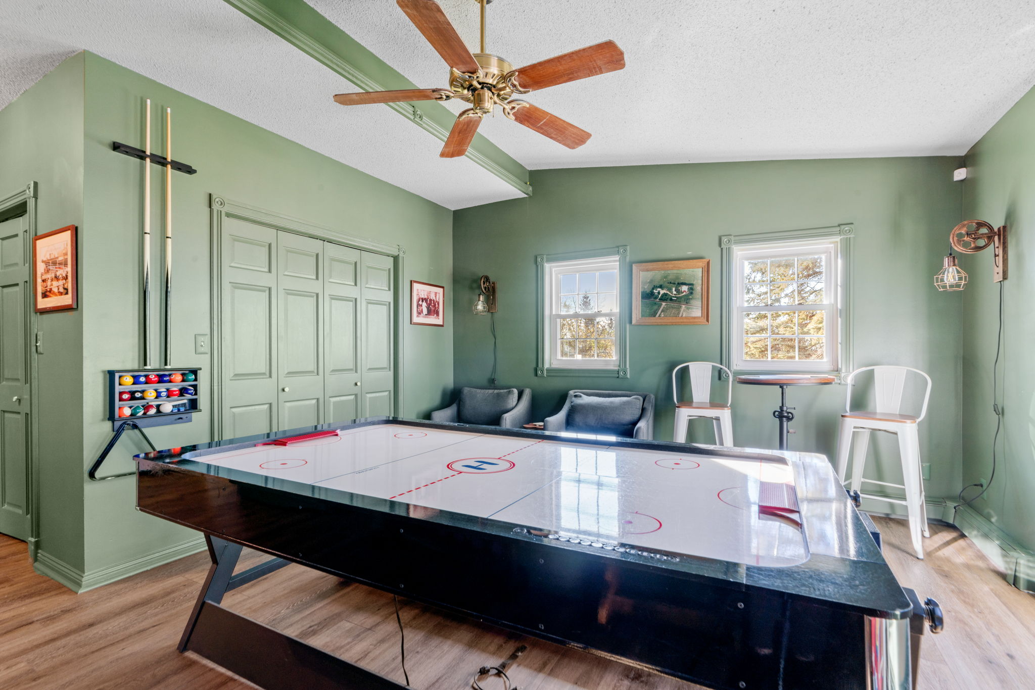 A cozy game room featuring an air hockey table and green decor.