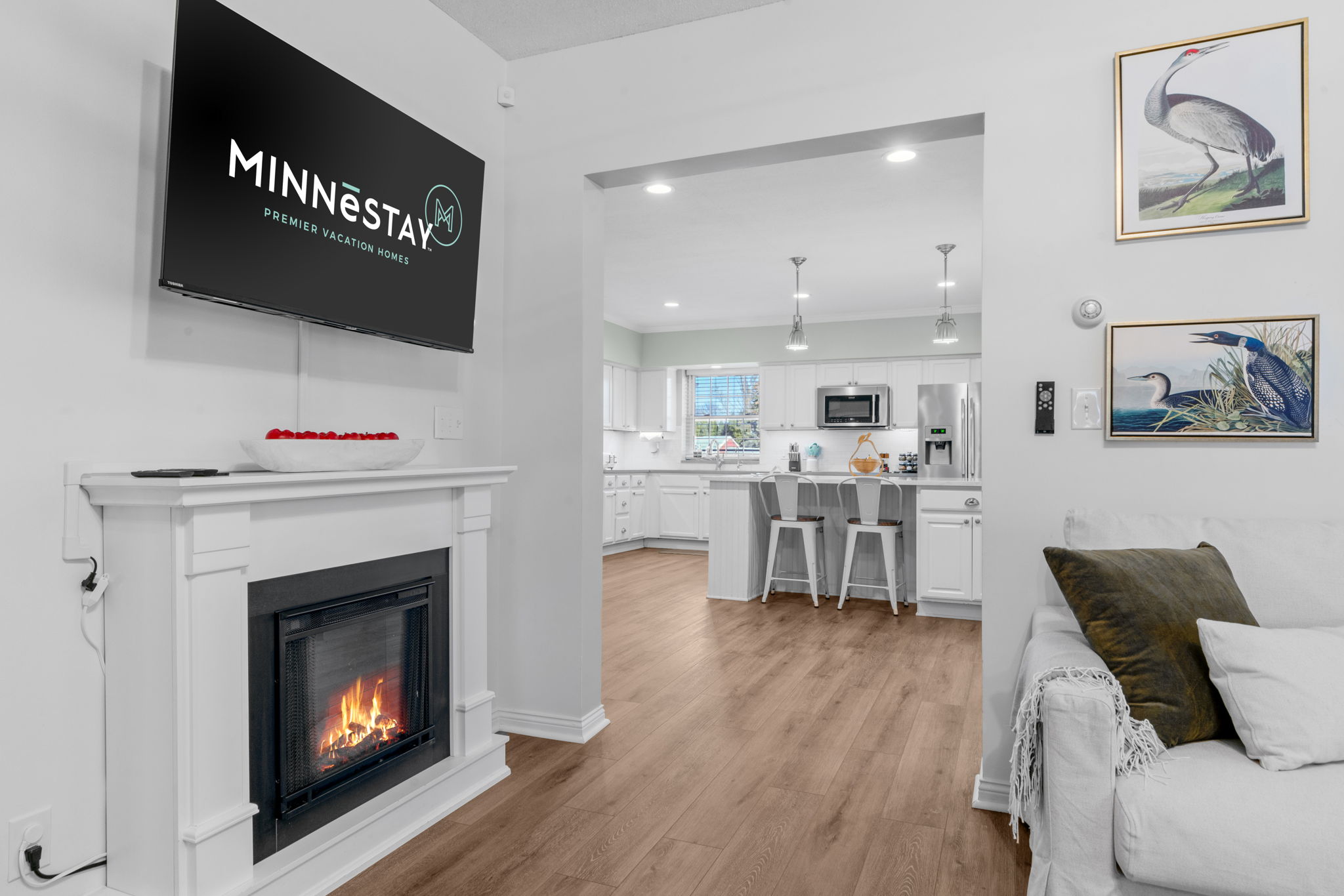 Modern living room and kitchen with a cozy fireplace and contemporary design.