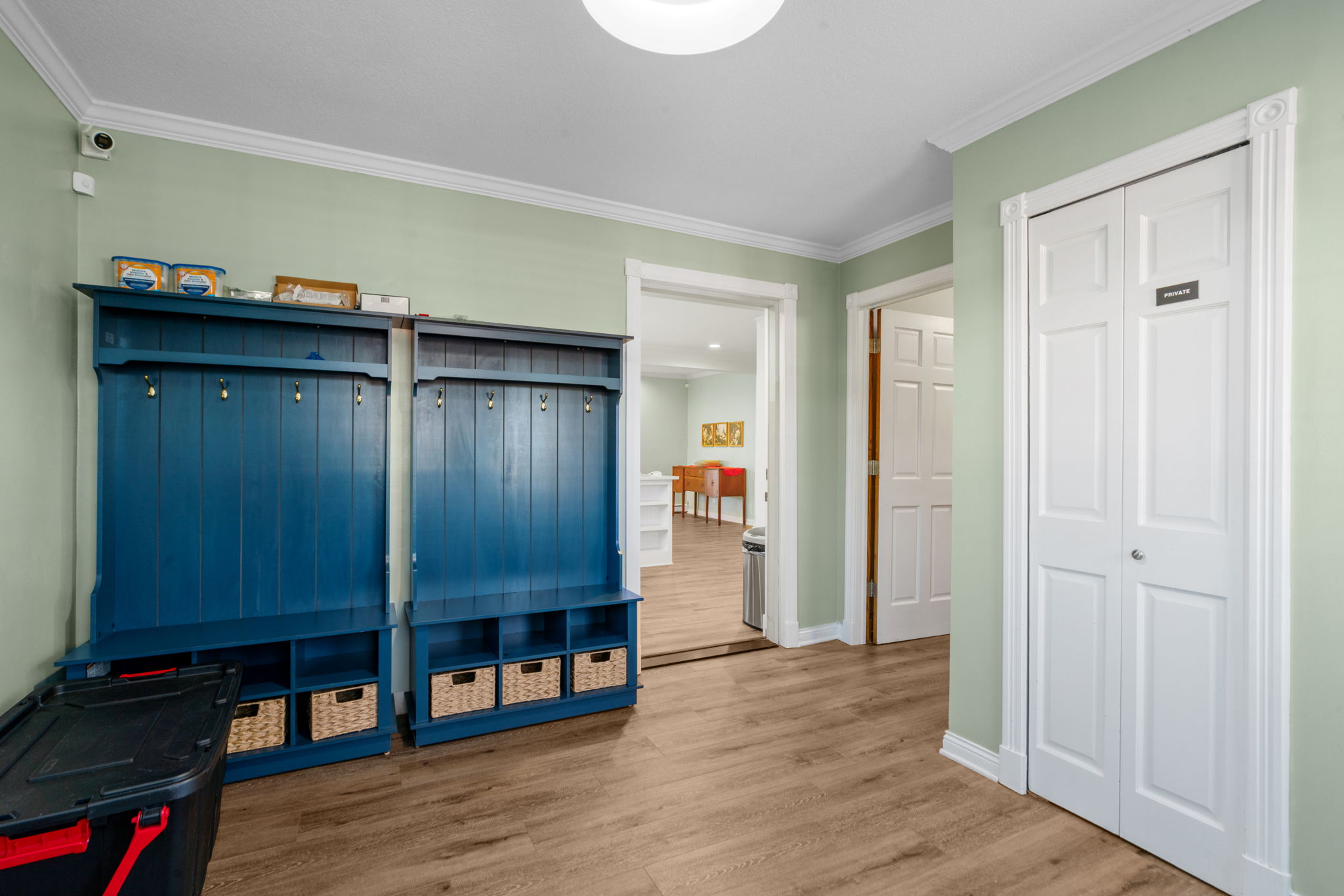 A welcoming entryway featuring stylish storage units and a light green wall.