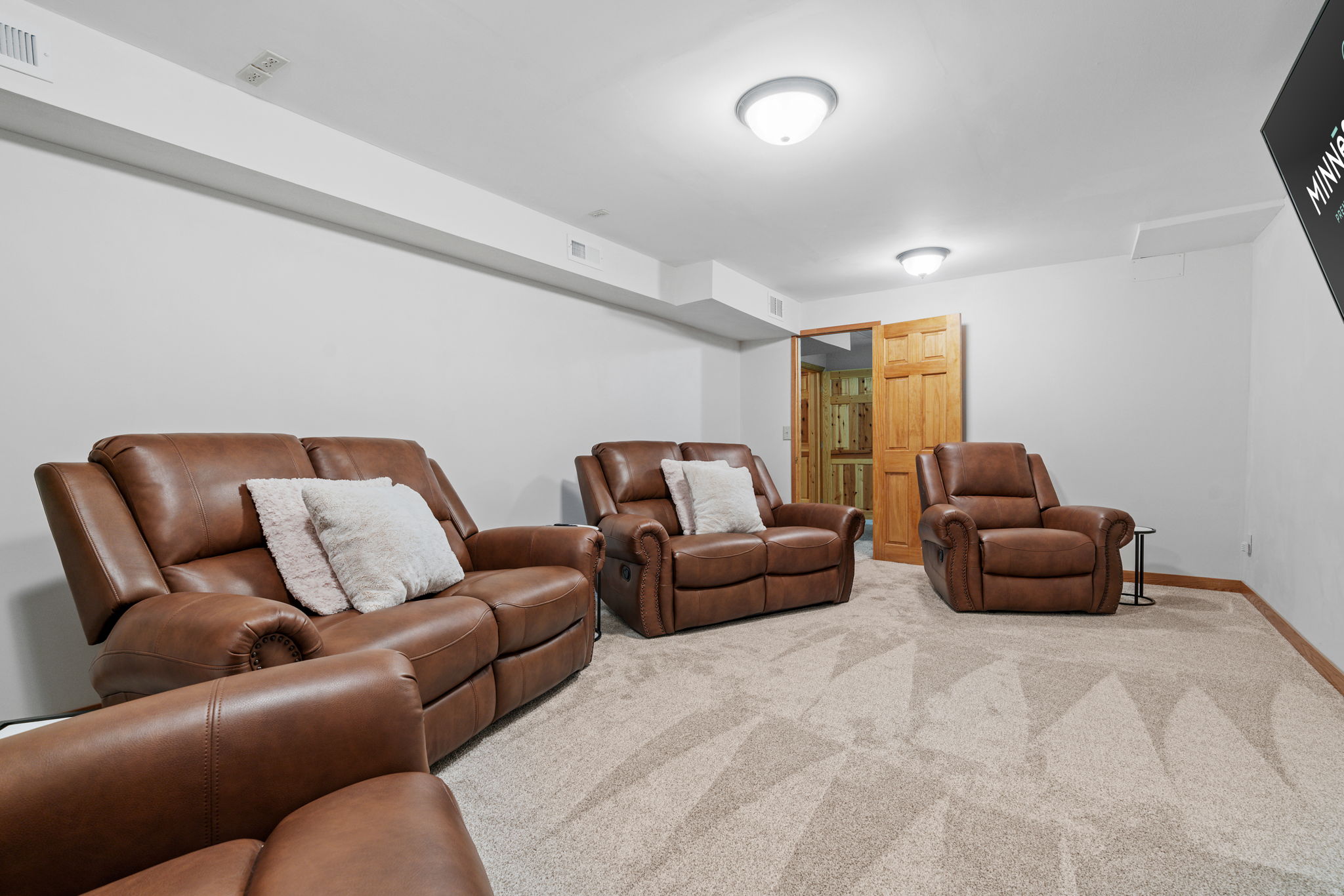 Cozy leather recliners in a well-lit basement lounge.