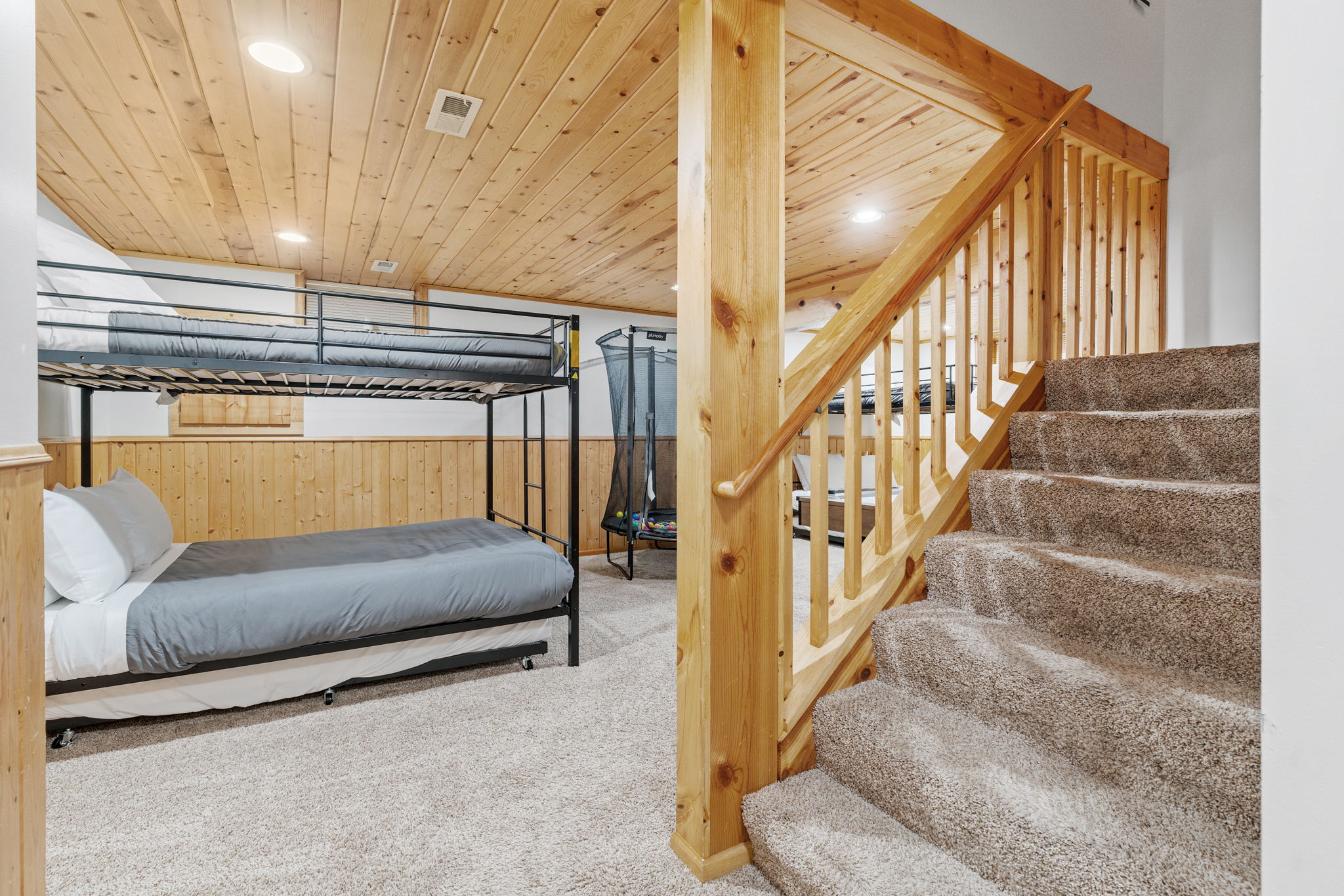 Cozy basement bedroom featuring a bunk bed and a warm wooden ambiance.