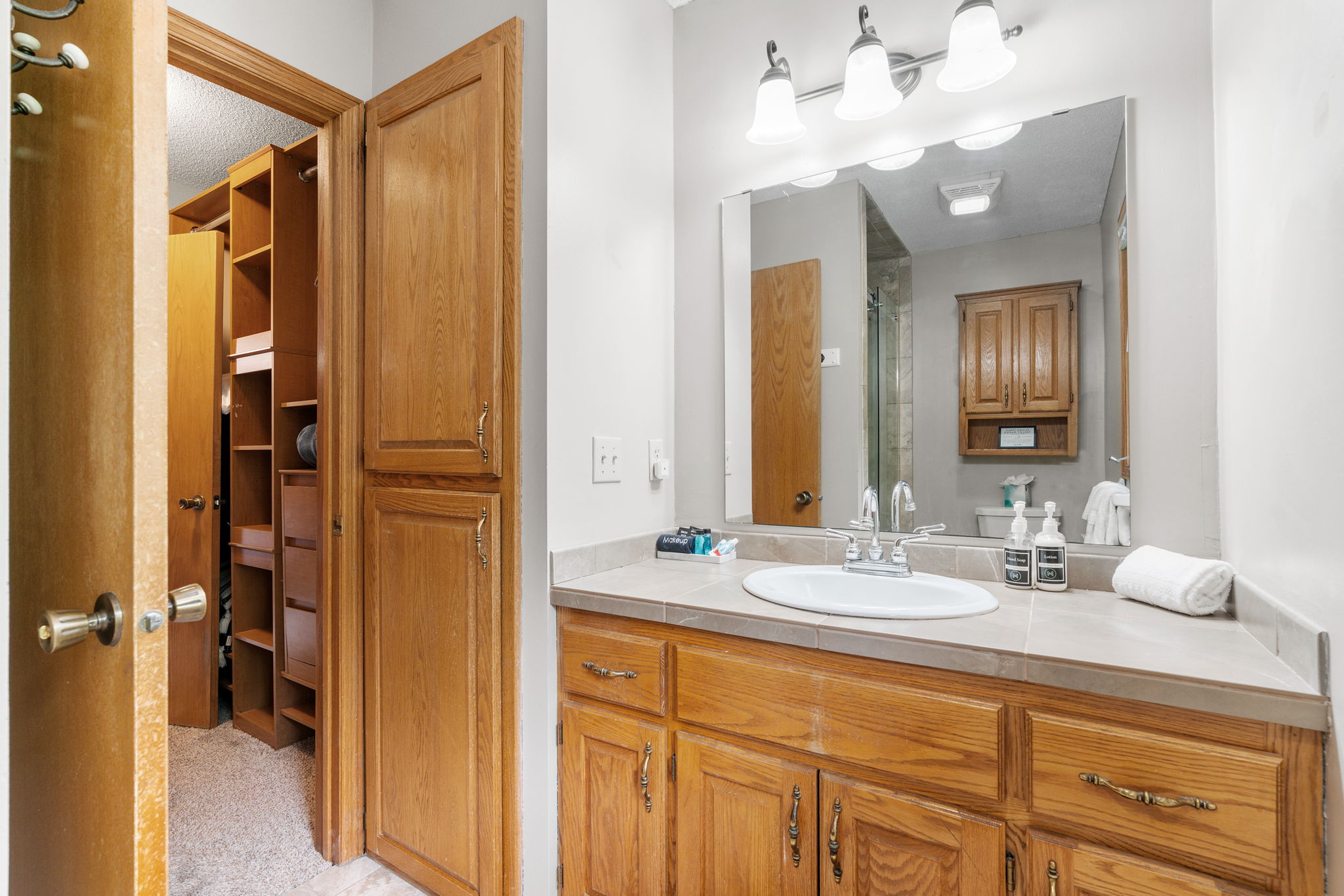 A cozy bathroom with wooden cabinets and organized toiletries.