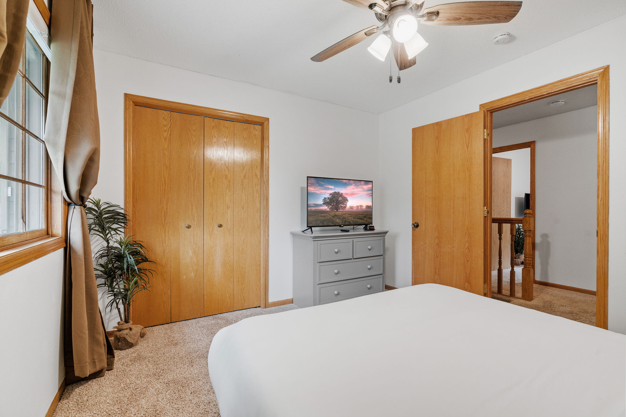 A cozy and inviting bedroom with natural light and warm wooden accents.