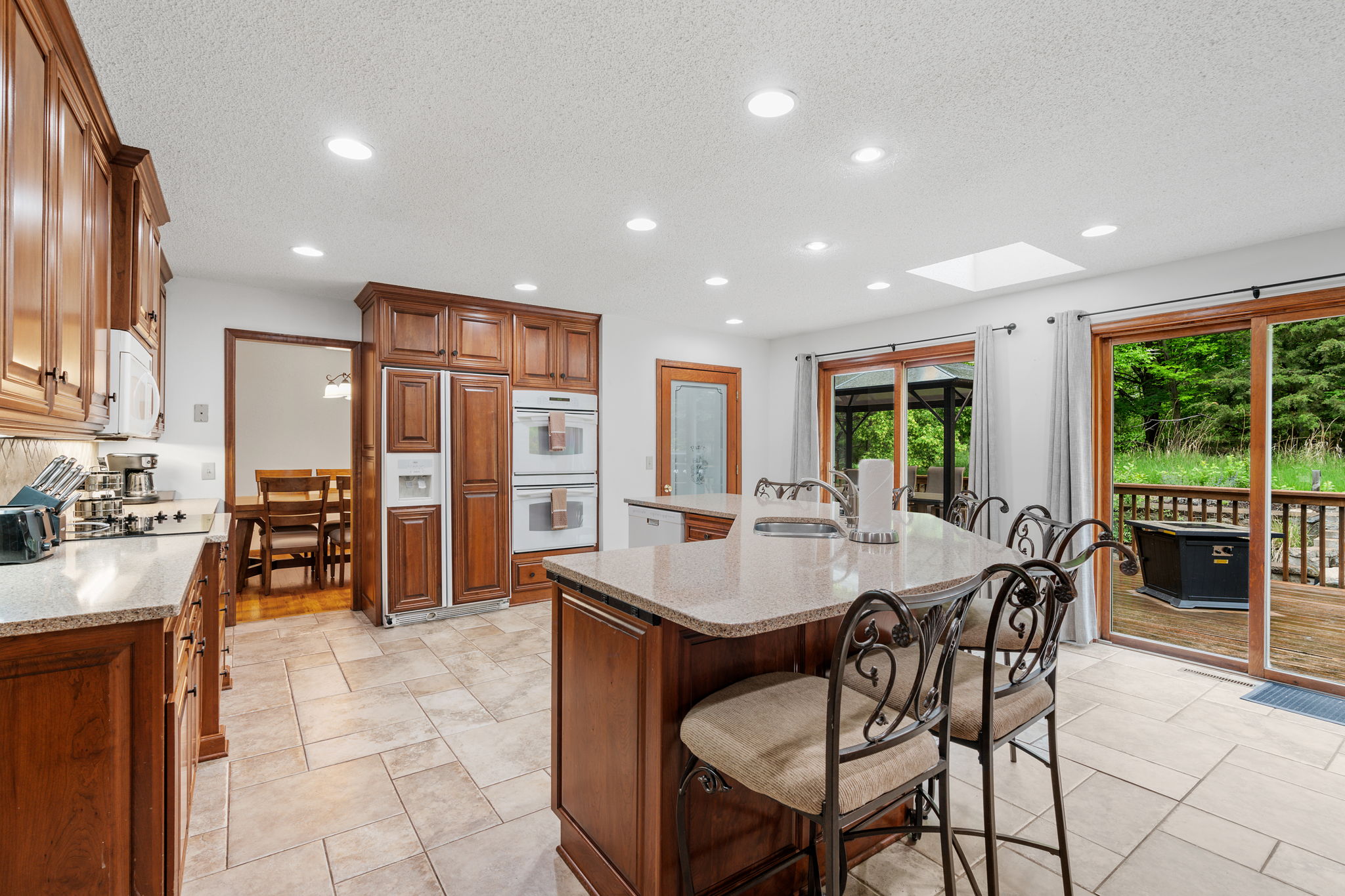 An inviting kitchen with elegant cabinetry and modern appliances, featuring a view to an outdoor deck.