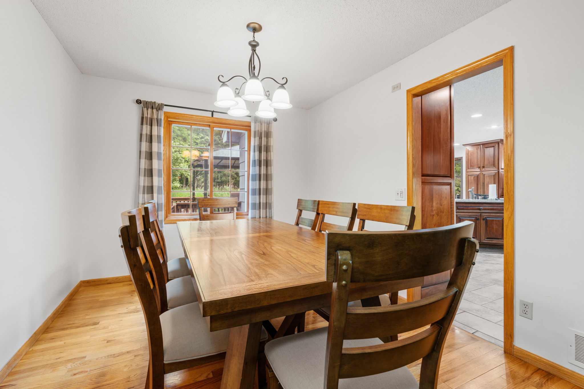 Cozy dining room with a wooden table and elegant chandelier.