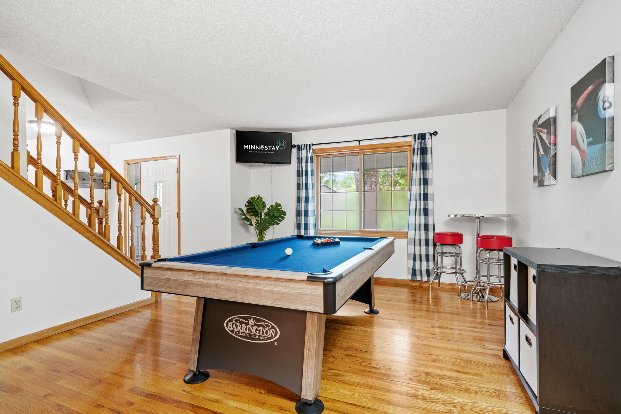 A vibrant game room featuring a billiards table and modern seating.