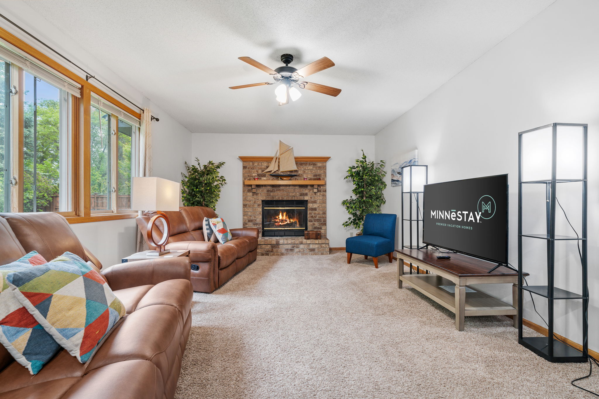 A cozy living room with leather seating, a fireplace, and modern decor.