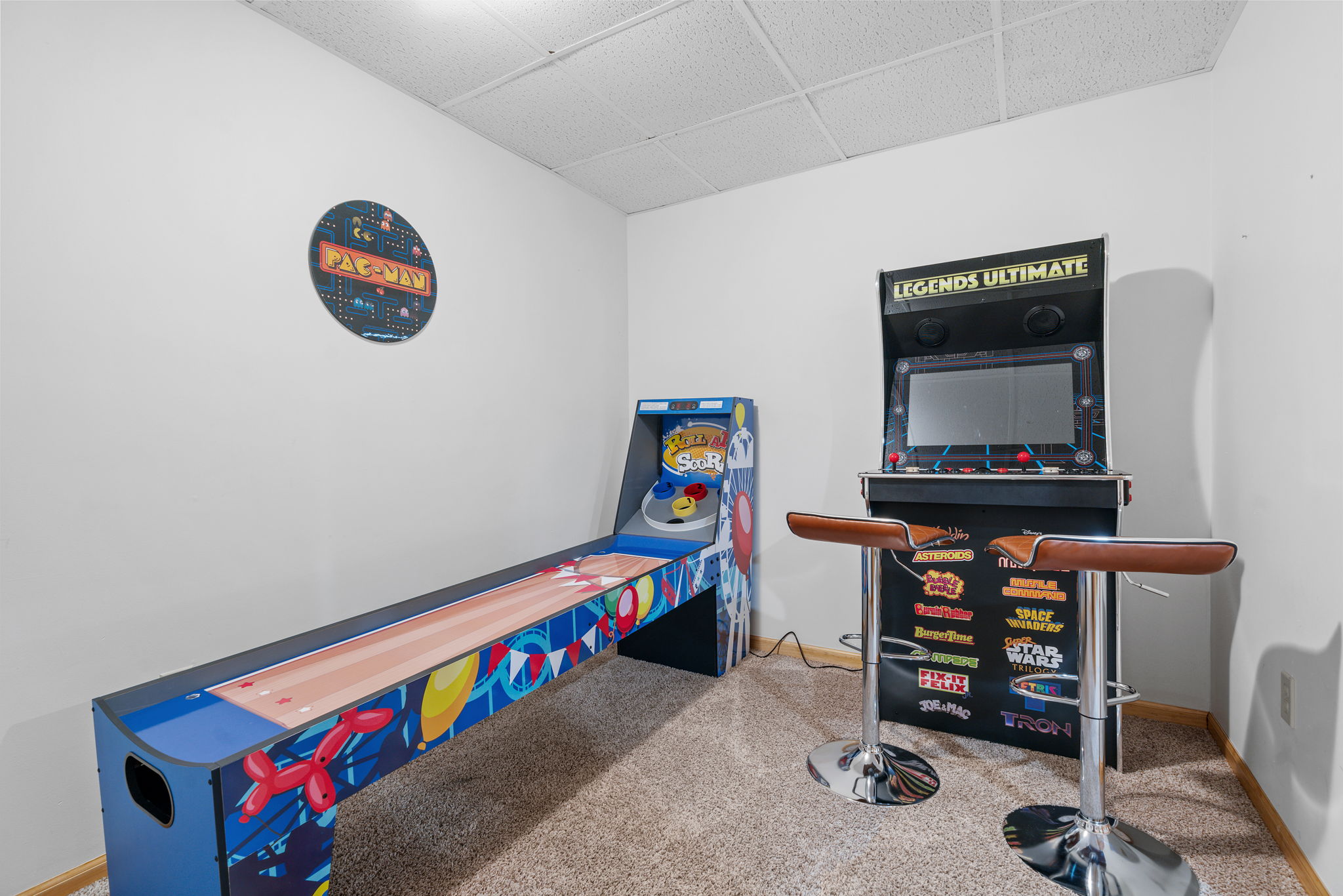 A vibrant gaming corner featuring classic arcade machines and a Pac-Man decoration.